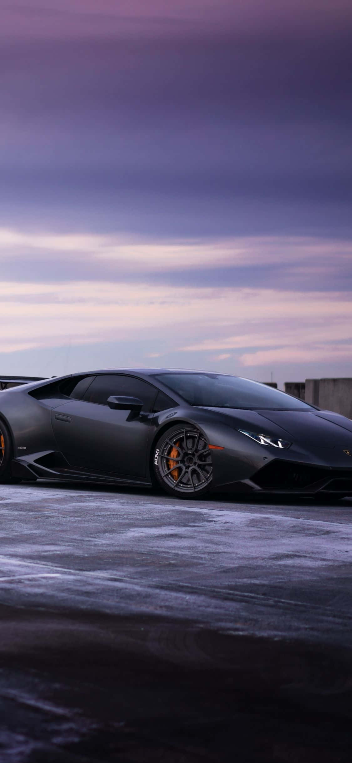 a black lamborghini parked on a snowy road Picha ya Ukuta