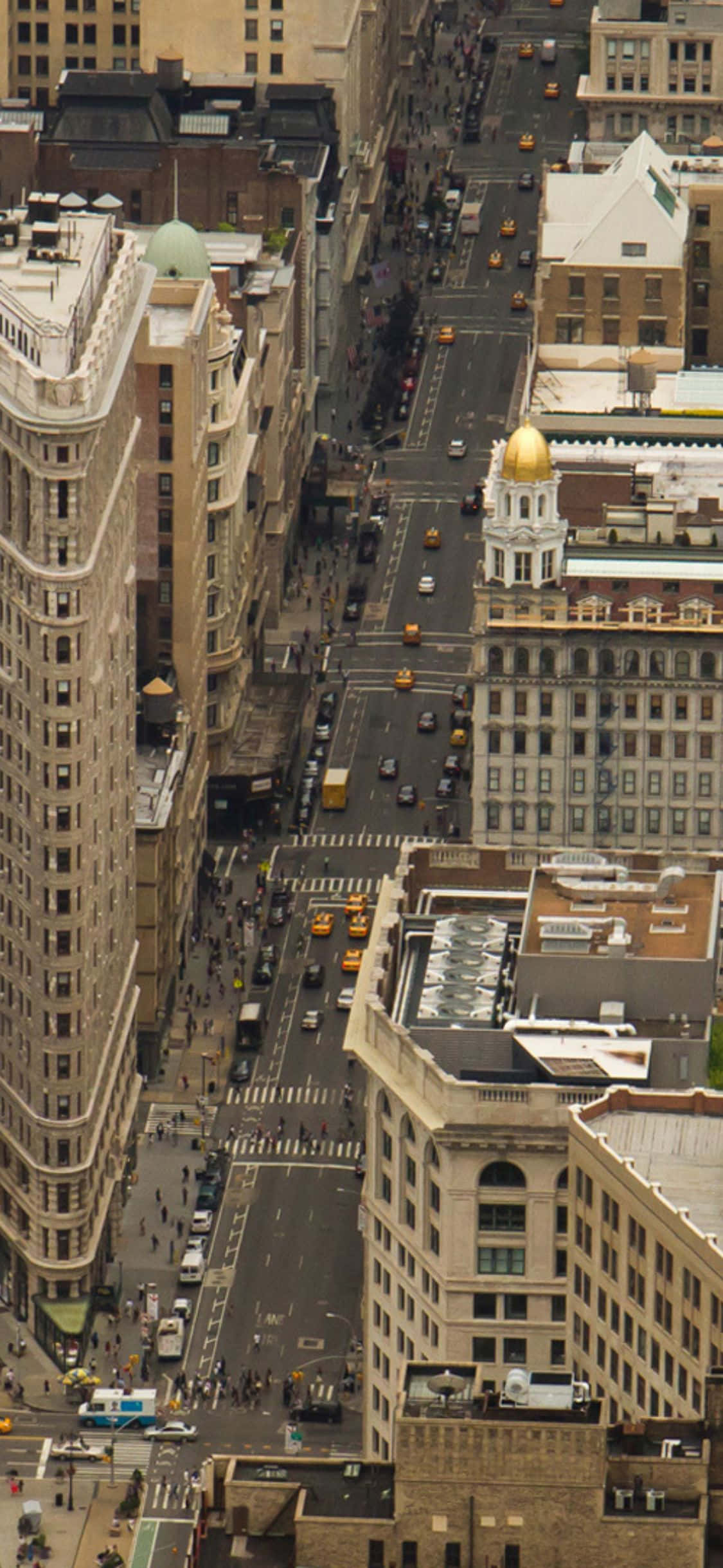 a city street with a large building Picha ya Ukuta