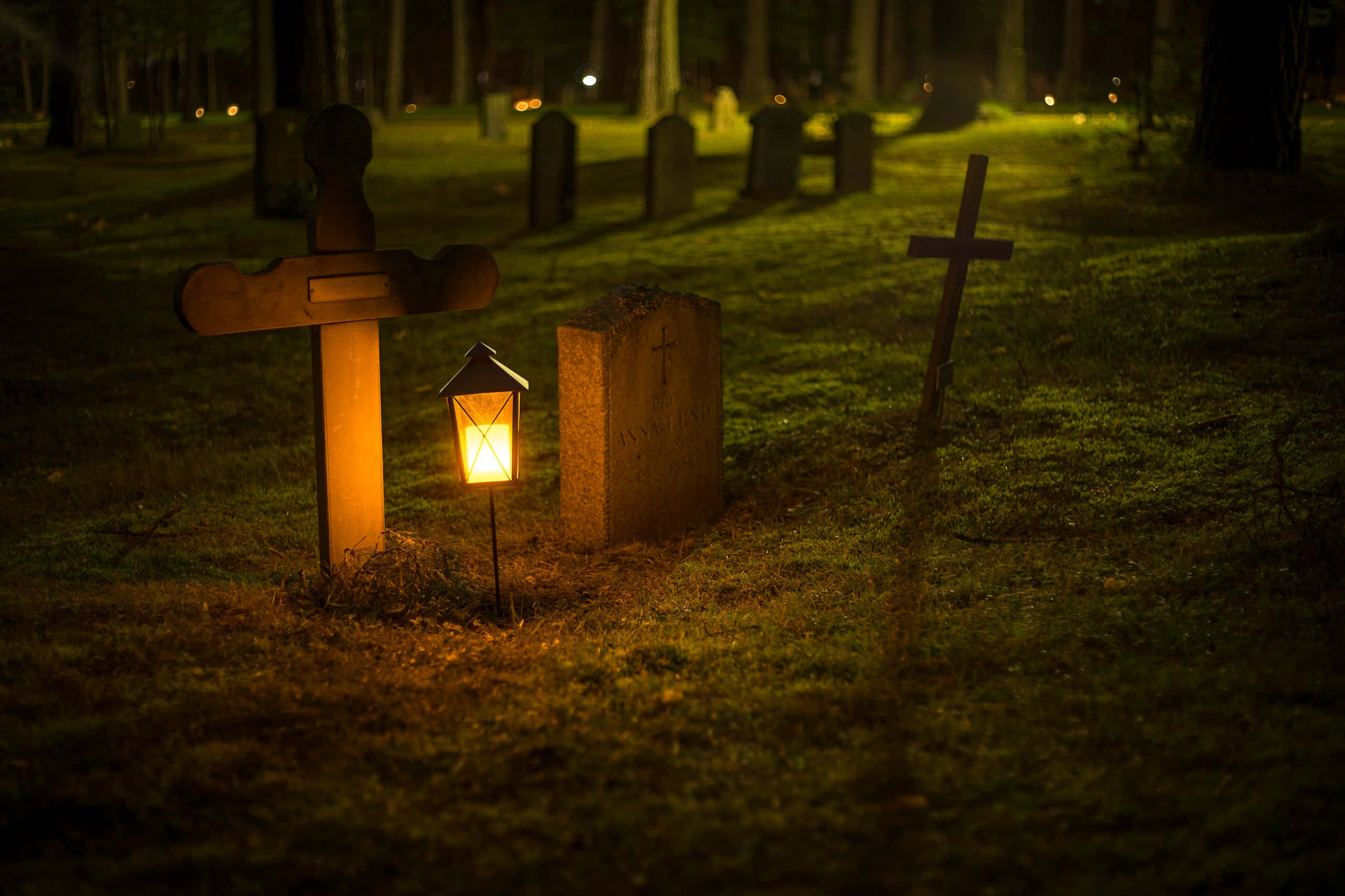 a graveyard with gravestones and a gravestone lit up Picha ya Ukuta