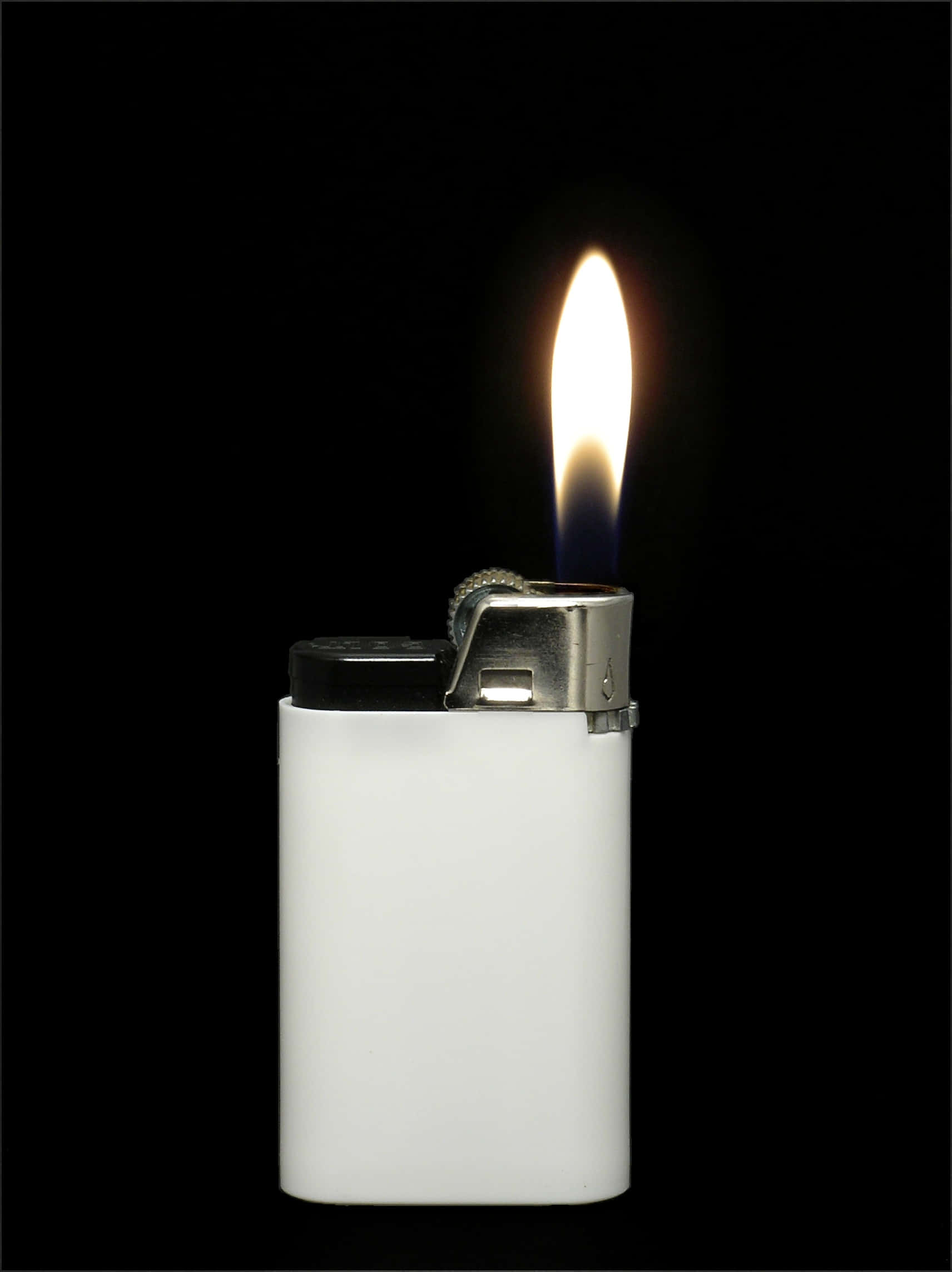 A shining lighter sparks flame in the darkness Picha ya Ukuta