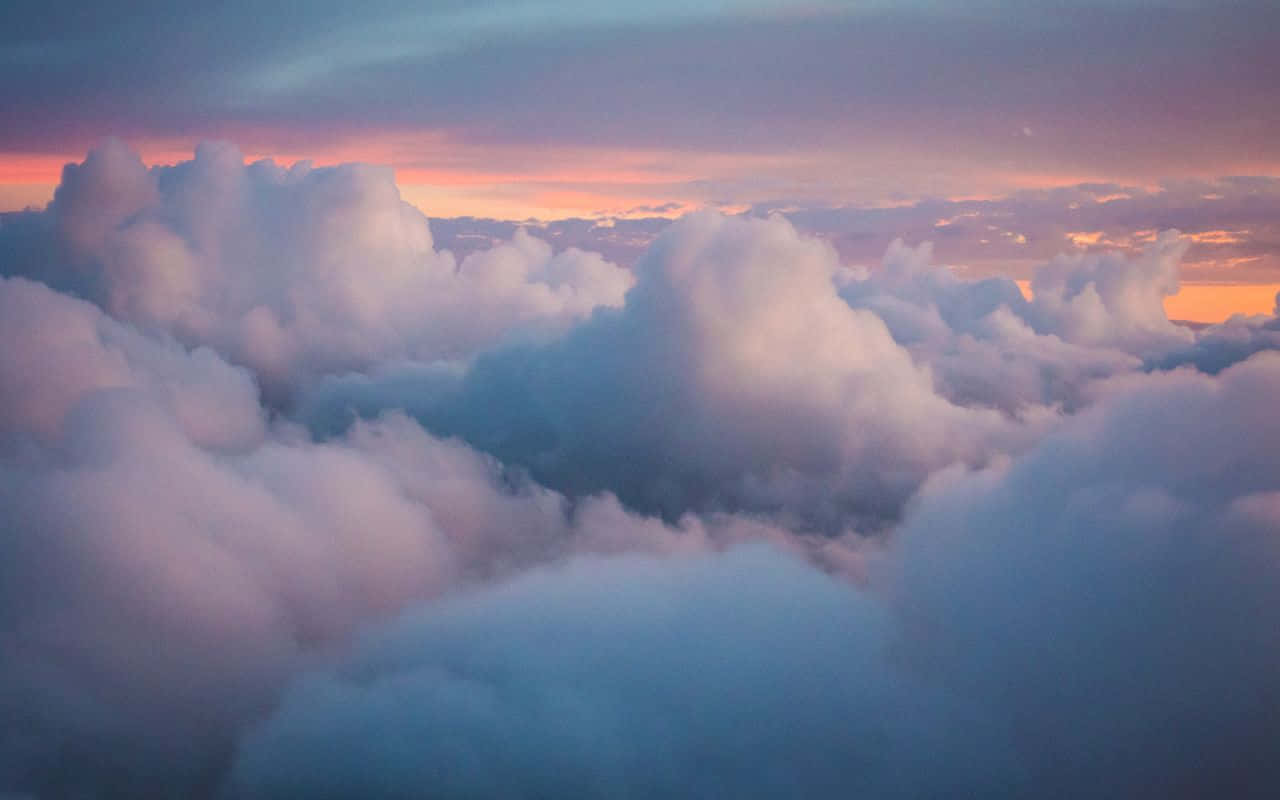 a view of clouds from an airplane at sunset Picha ya Ukuta