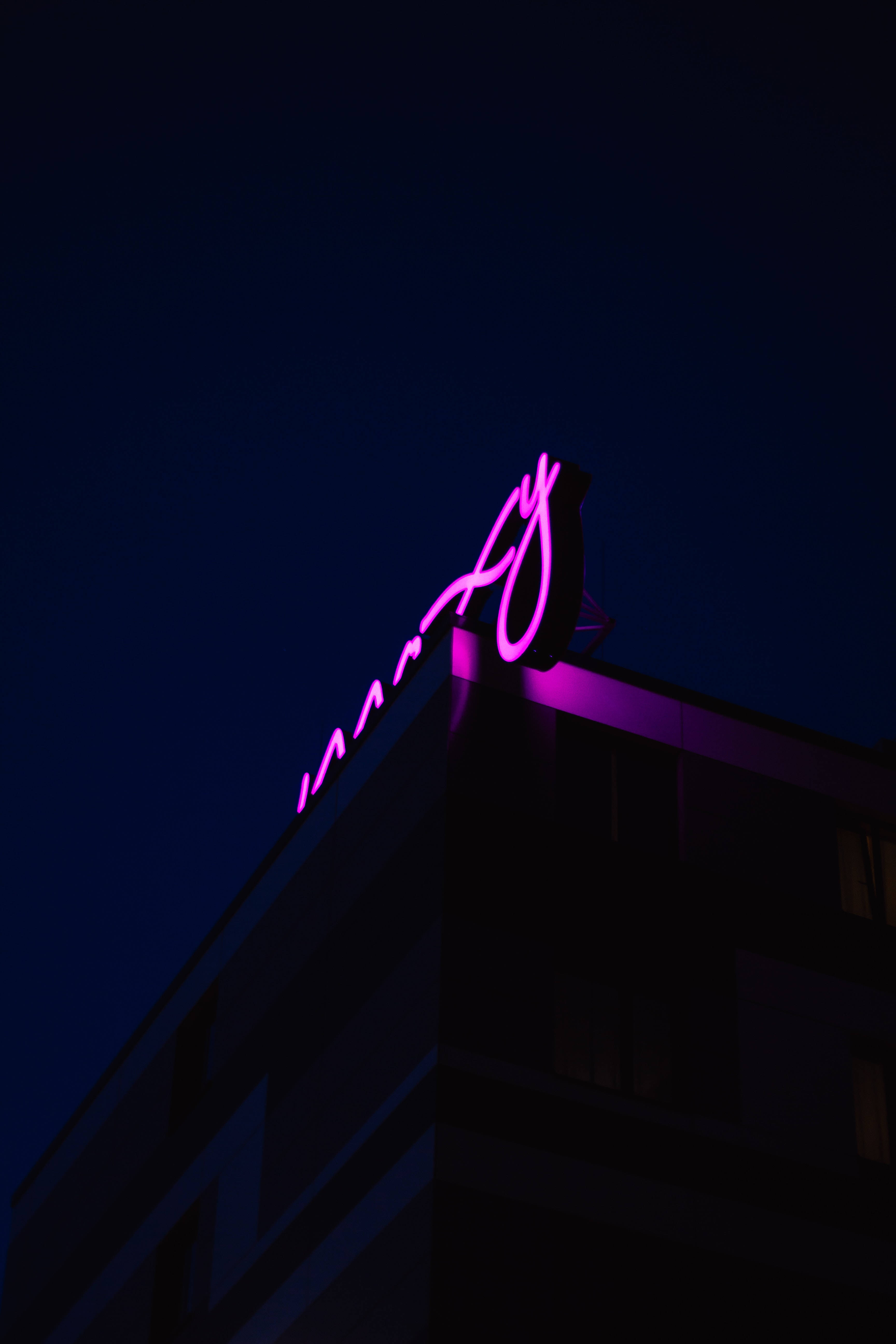 Alama ya Neon ya Zambarau Juu ya Paa Picha ya Ukuta