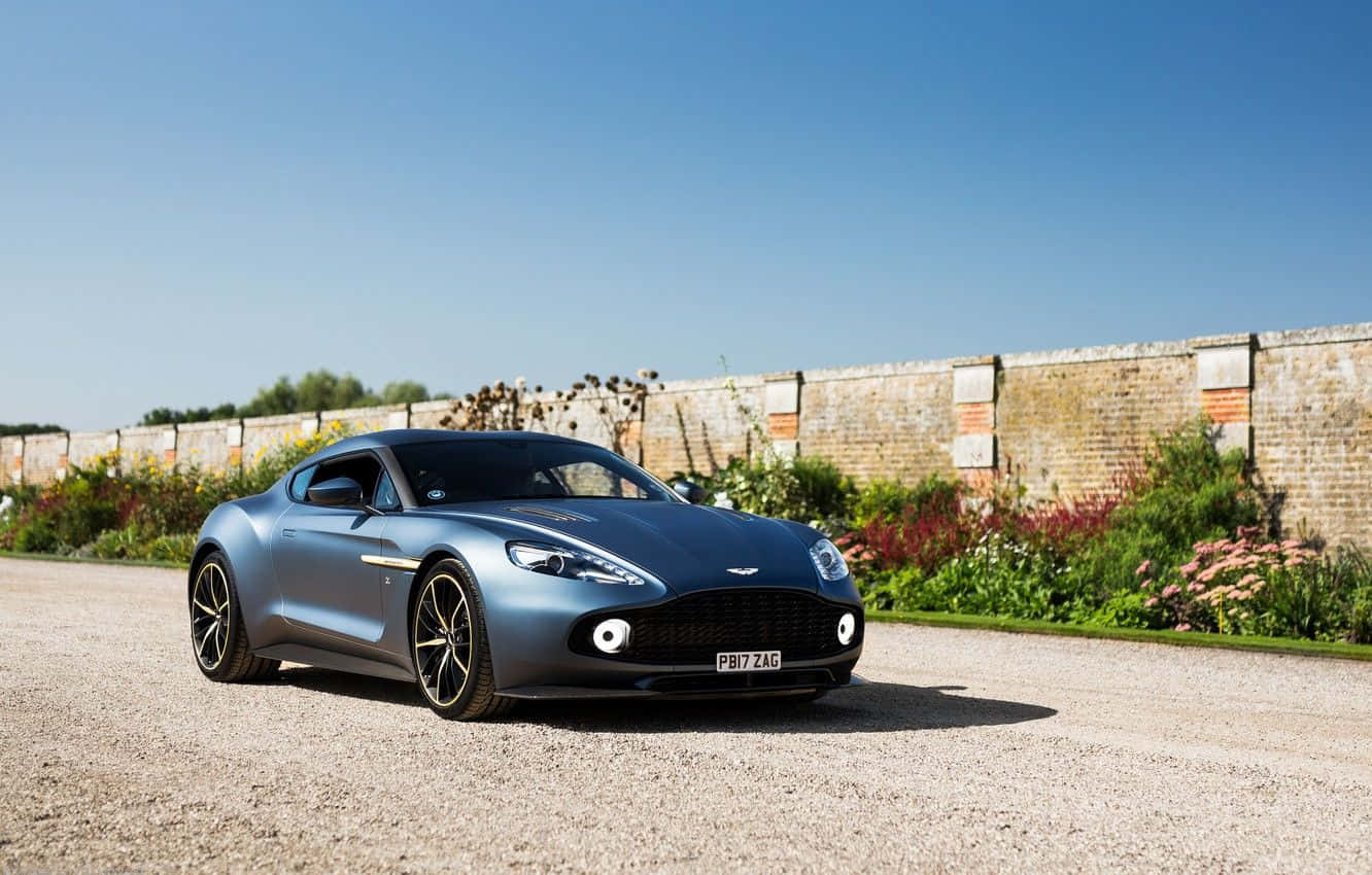 Aston Martin Vanquish Kuvutia katika Mwendo kwenye Barabara ya Kuvutia Picha ya Ukuta