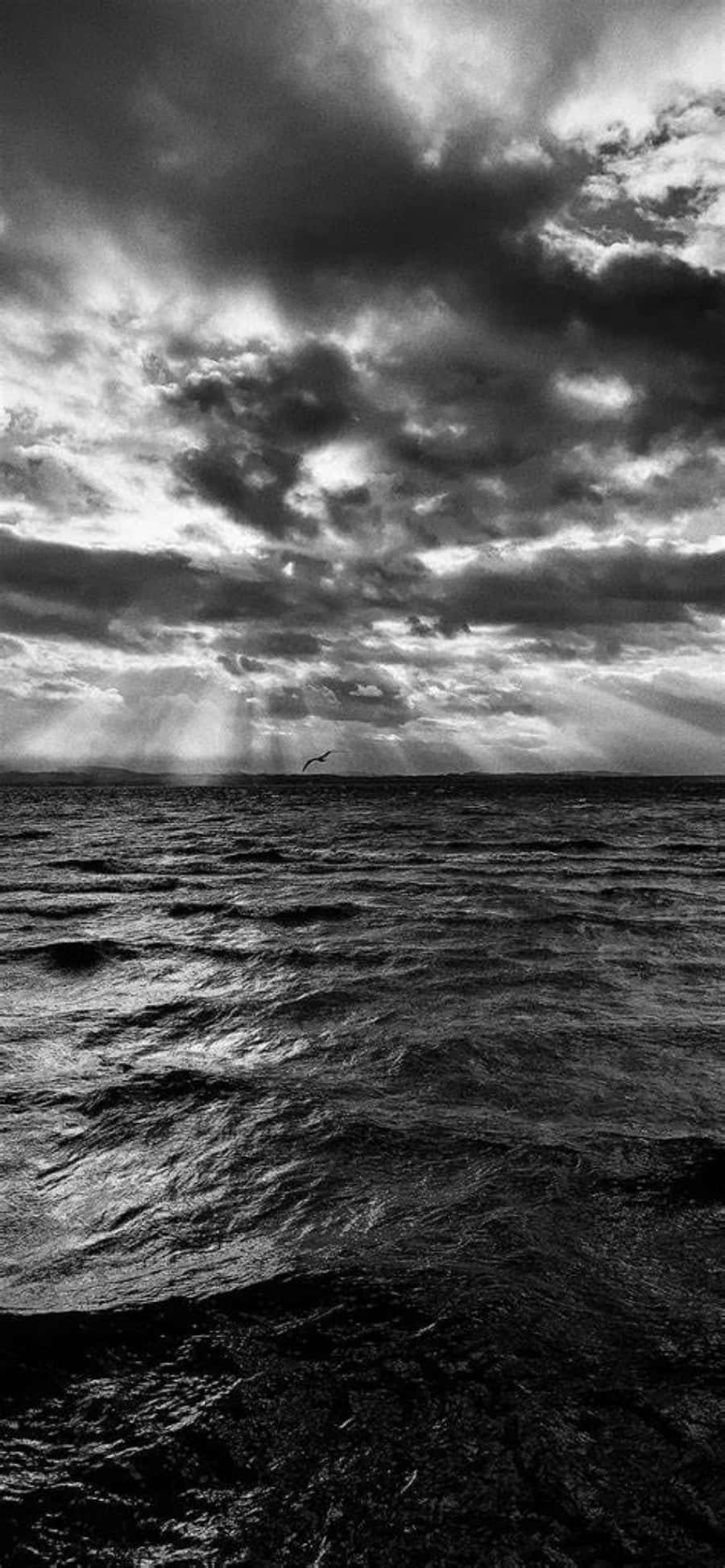 black and white photo of a cloudy sky over the ocean Picha ya Ukuta