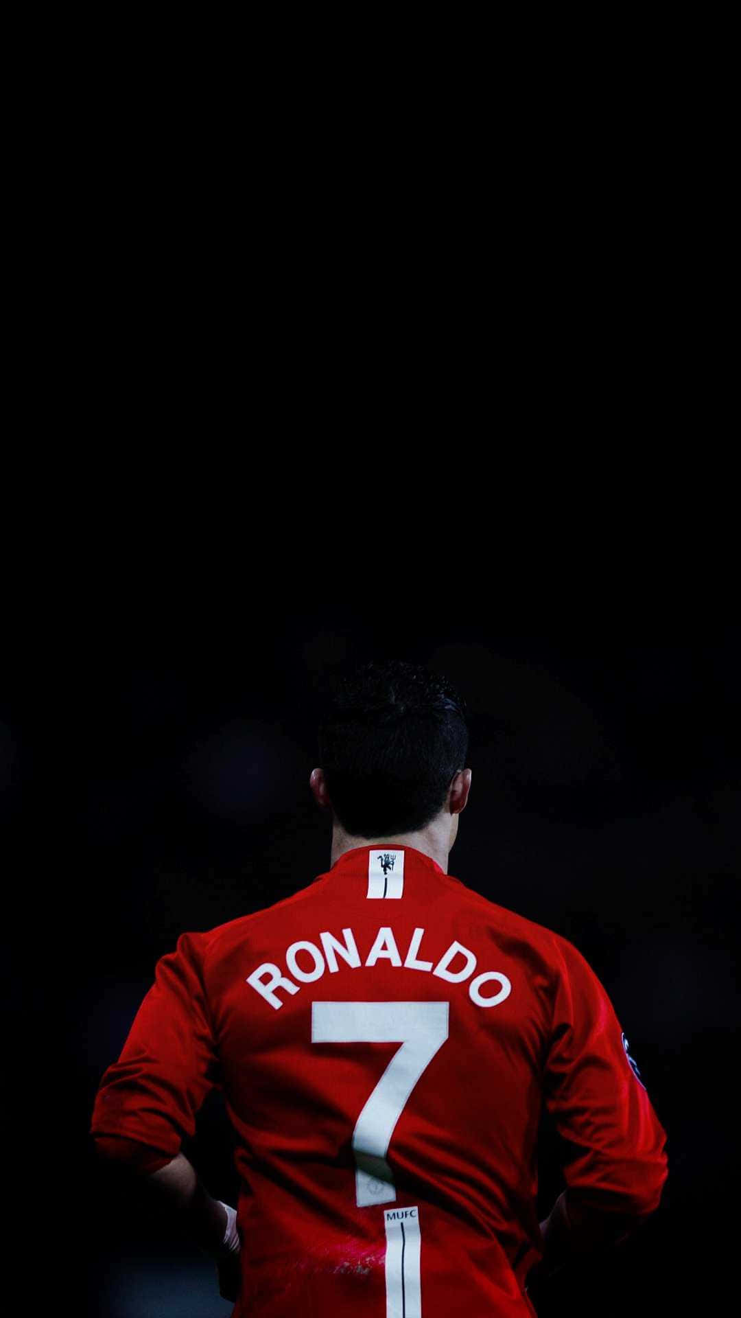 Cristiano Ronaldo akifyatua mpira kwa nguvu uwanjani Picha ya Ukuta