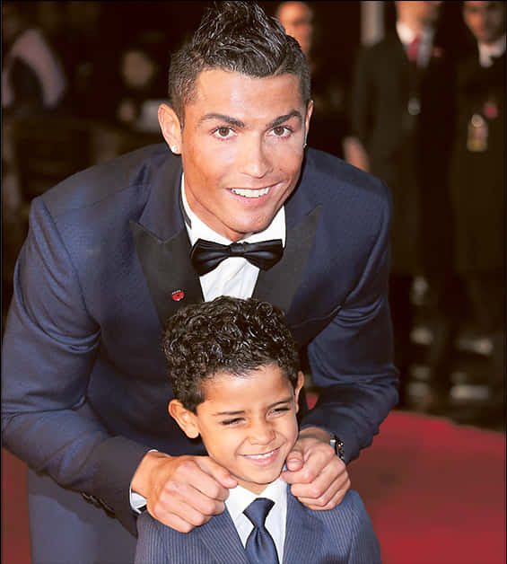 Cristiano Ronaldo Akitabasamu Na Mtoto Katika Hafla Picha ya Ukuta