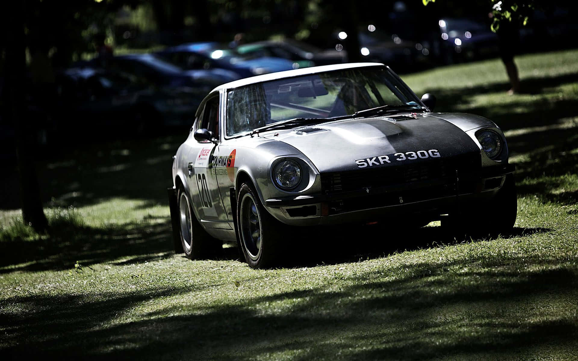Datsun ya Klasiki Inayosafiri Kwa Kasi Kwenye Barabara ya Wazi Picha ya Ukuta
