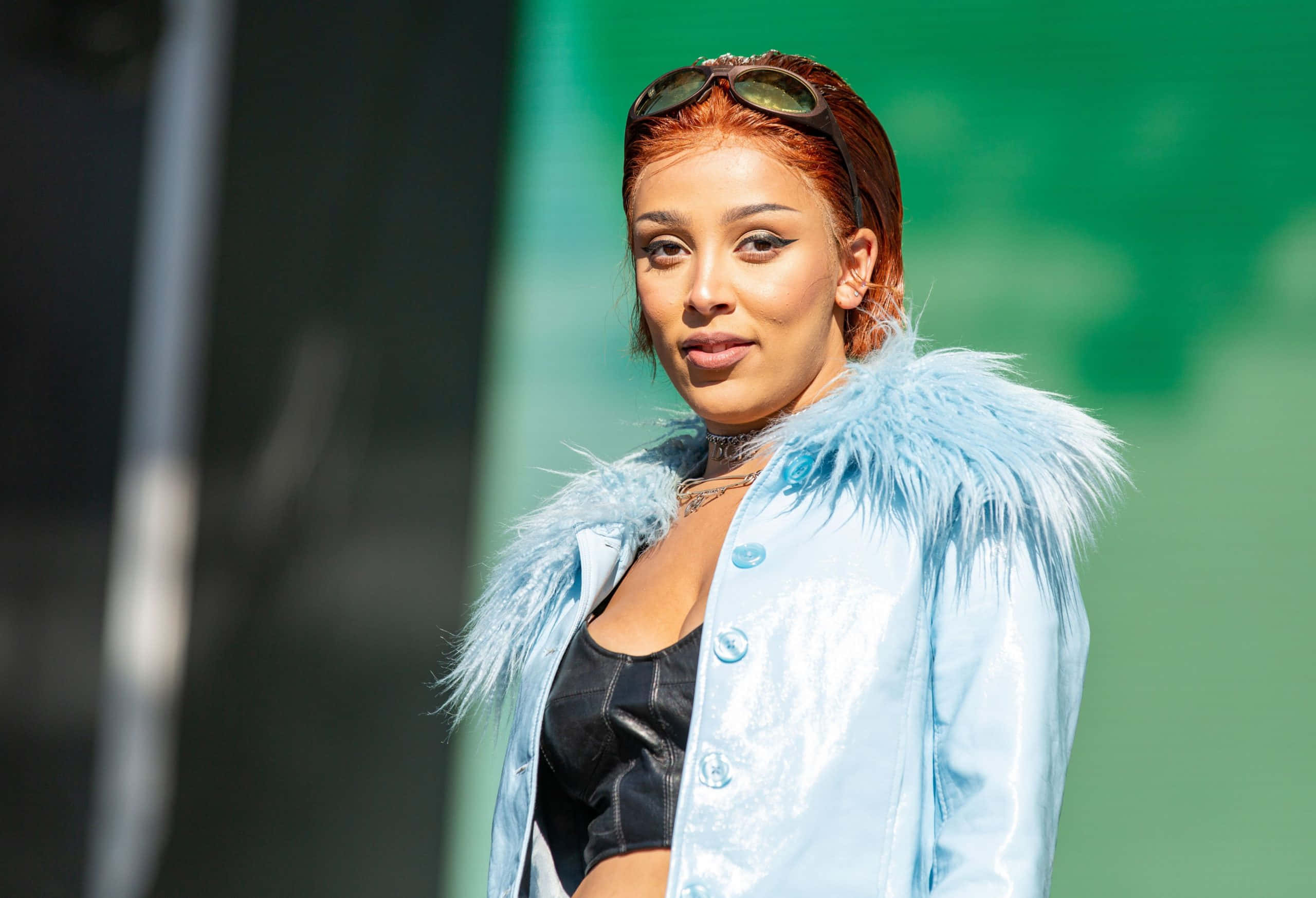 Doja Cat akiwa amevalia vazi la ngozi na lairikisi Picha ya Ukuta