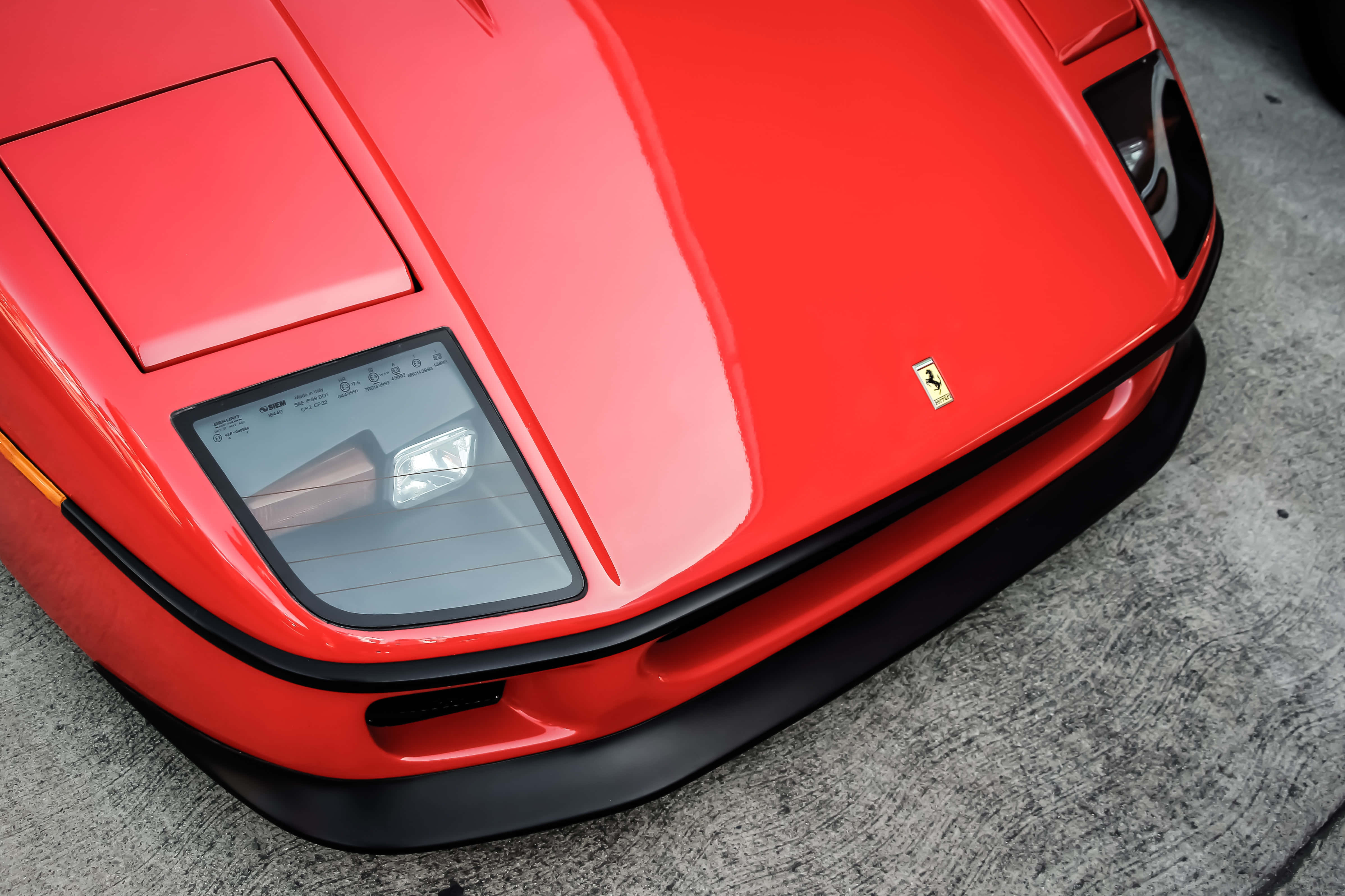 Ferrari nyekundu kwenye barabara inayojipinda katika mandhari ya baridi Picha ya Ukuta