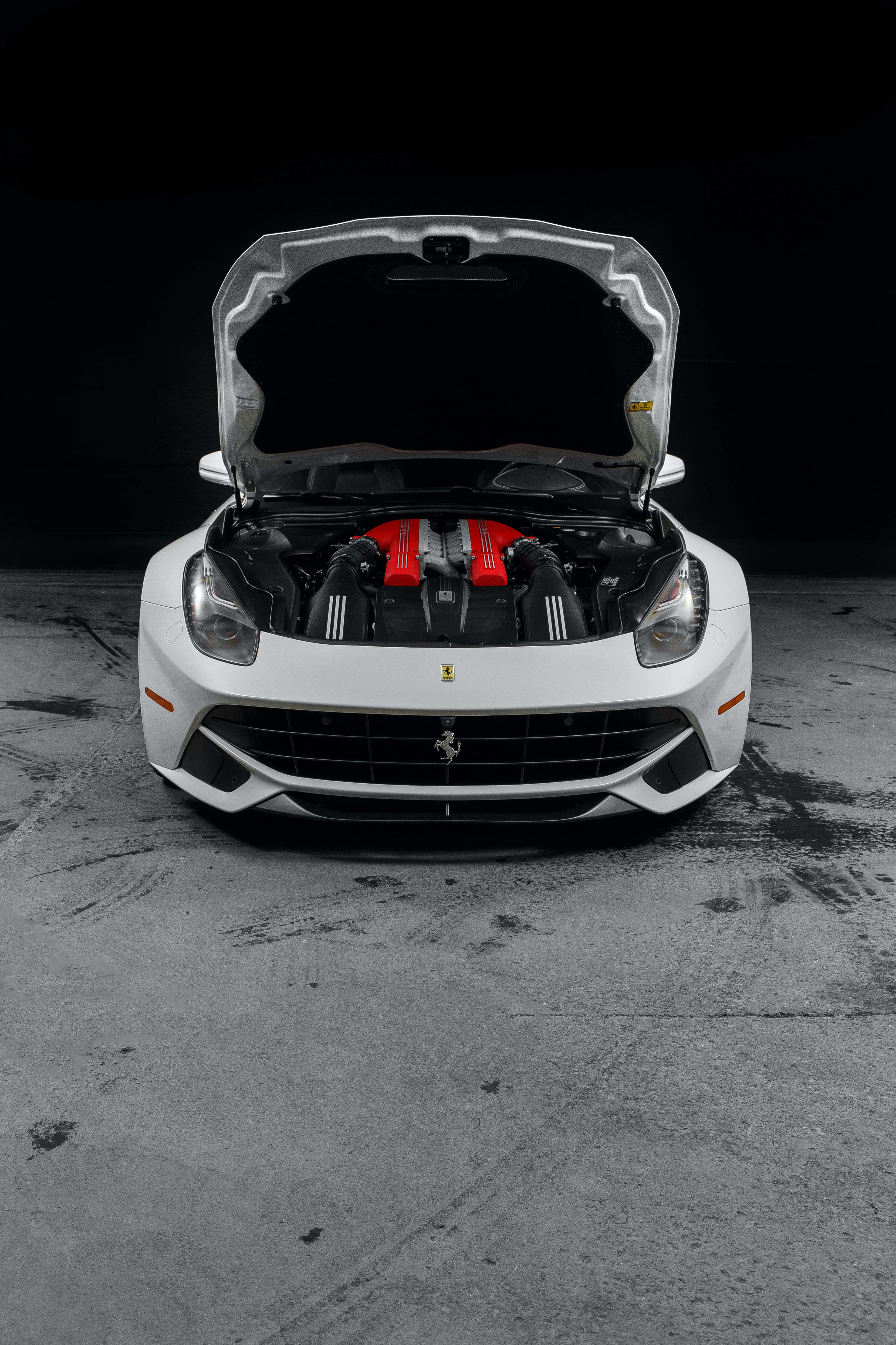 Ferrari Nyekundu ya Kasi Dhidi ya Saa ya Magharibi Picha ya Ukuta