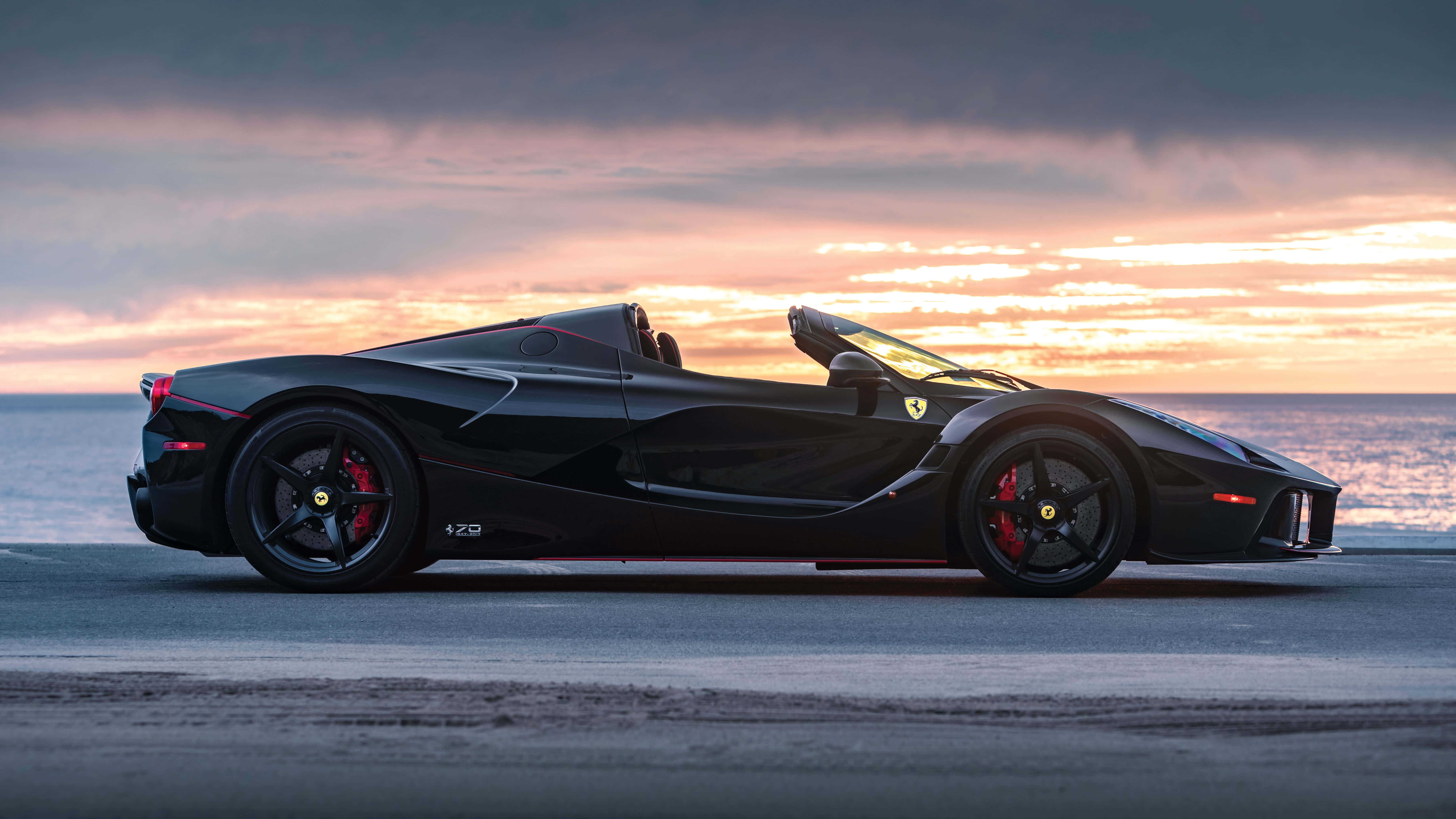 Gari Jeusi la Ferrari 4K Machweo Ufukweni Picha ya Ukuta