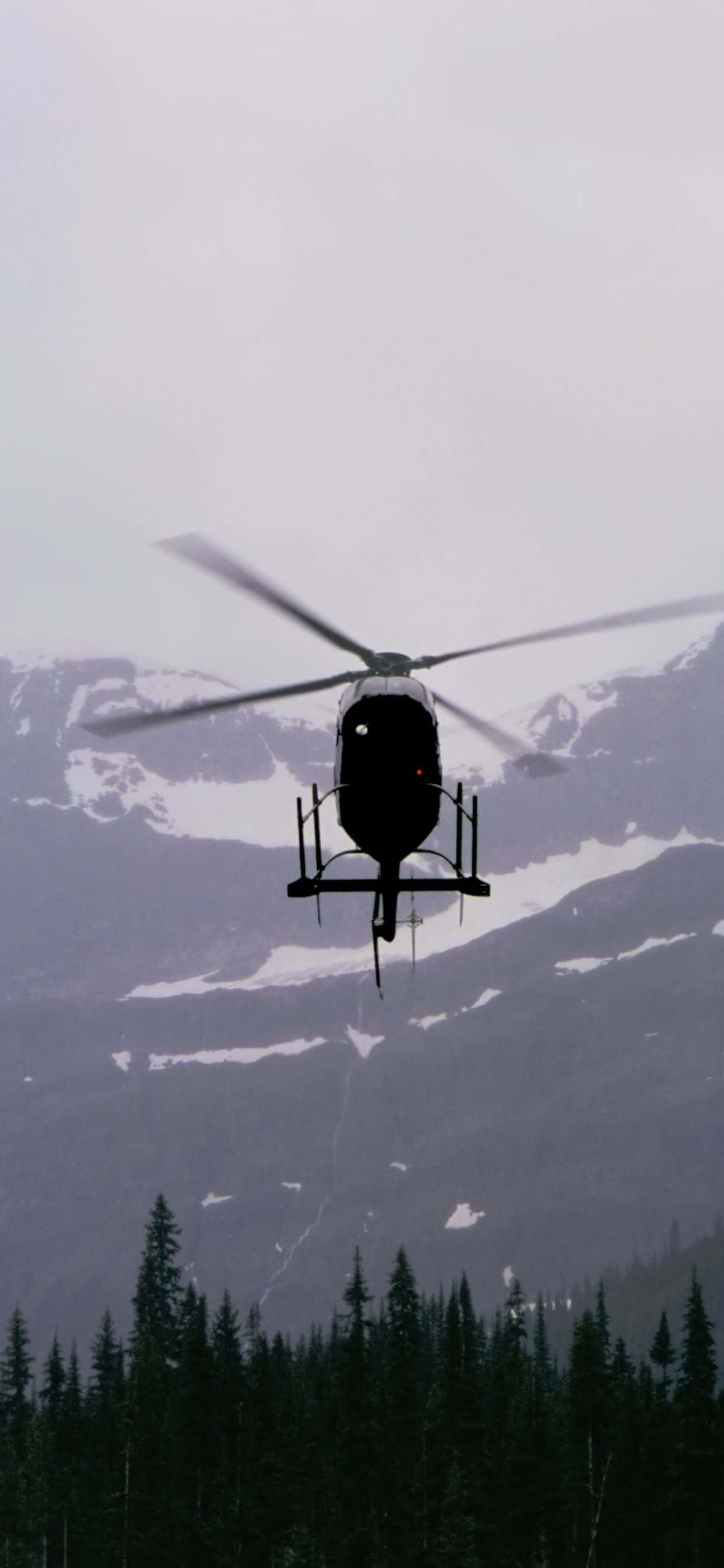 helikopta inayofuka juu ya safu ya mlima Picha ya Ukuta