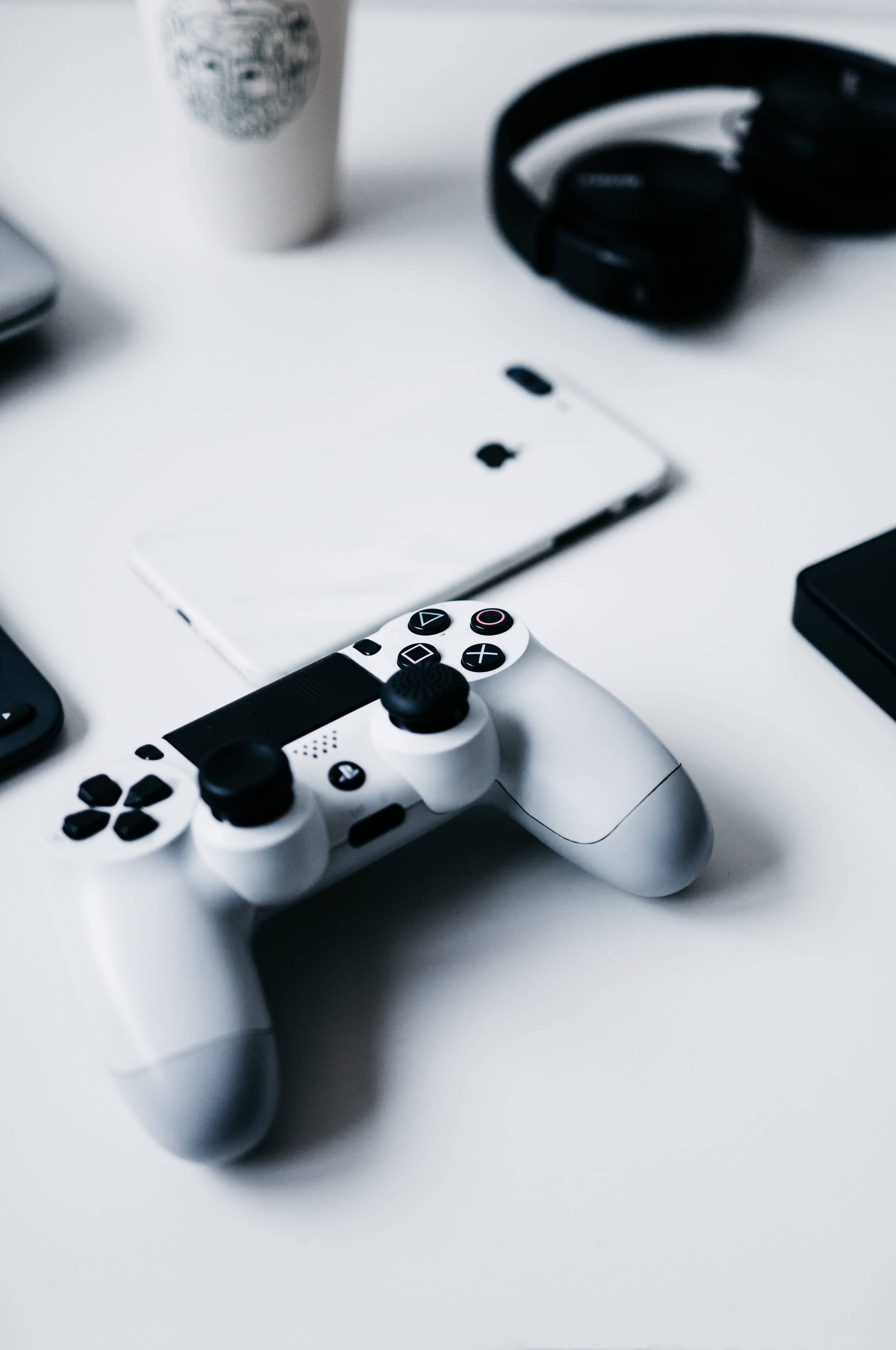 iPhone juu ya Maktaba na Kidhibiti cha PlayStation Picha ya Ukuta