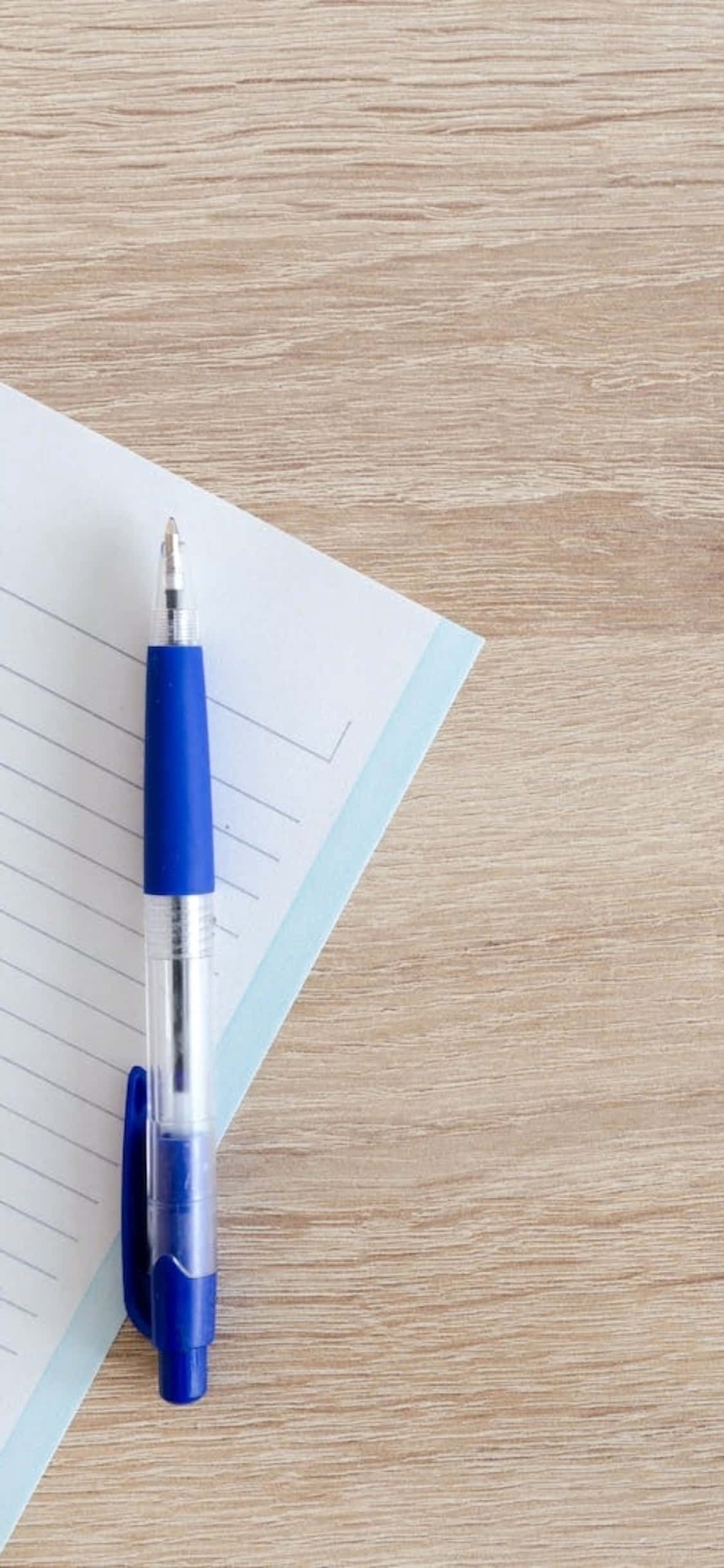 iPhone X Desk Background Blue Pen And A Notebook Picha ya Ukuta