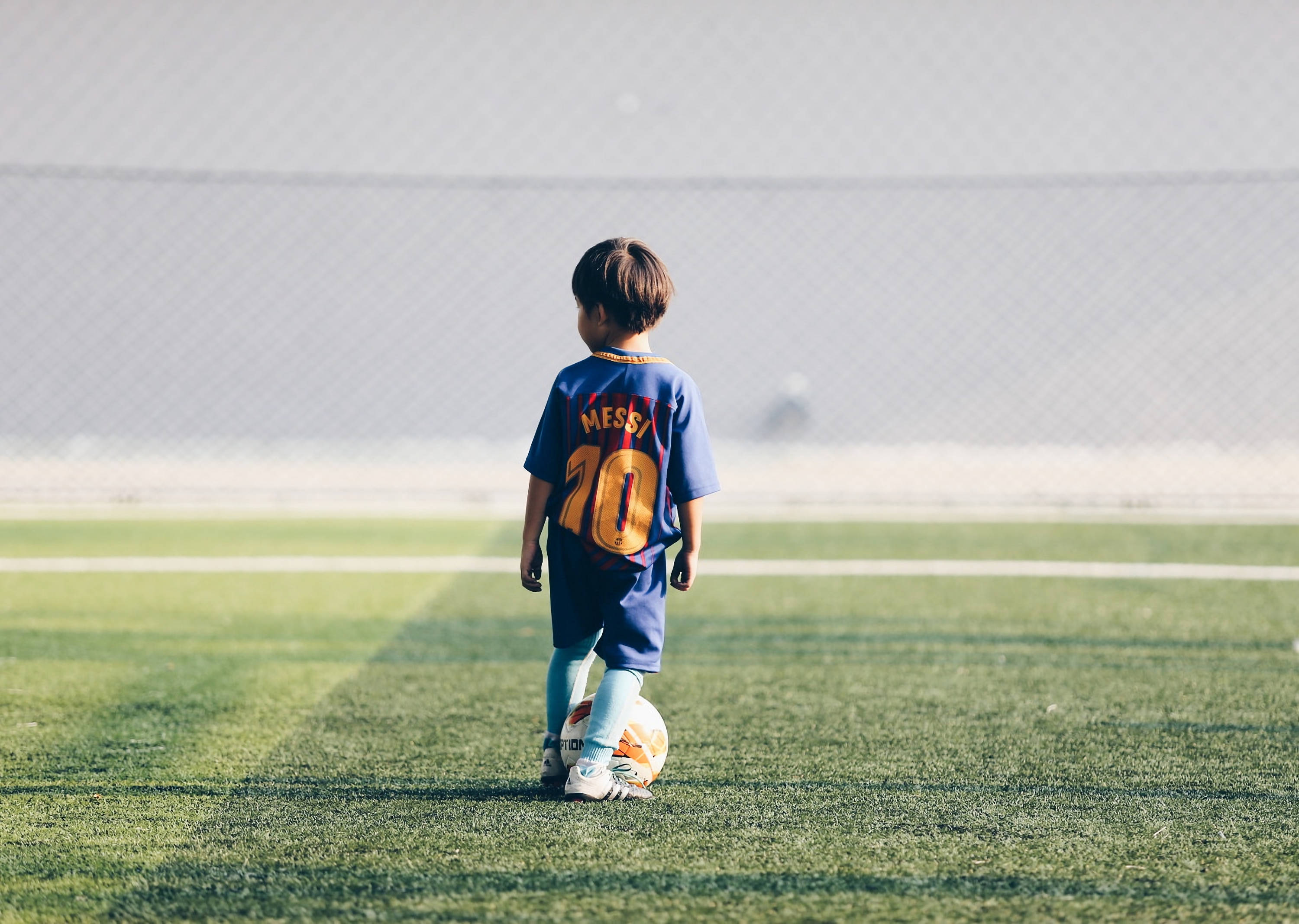 Kijana mwenye matumaini anatazamia siku atakayovaa jezi ya Lionel Messi. Picha ya Ukuta
