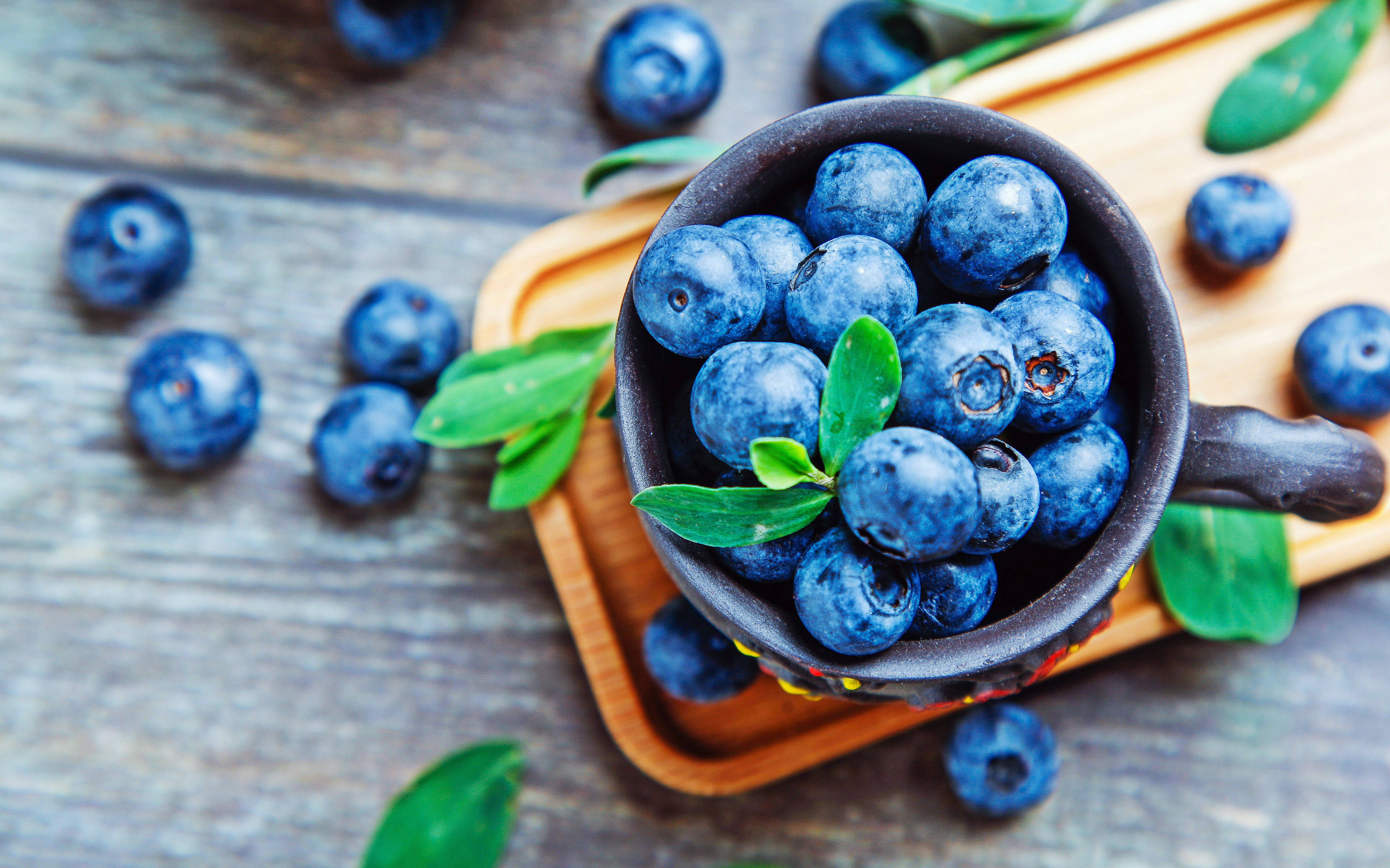 Kikombe cha Blueberries Juu ya Meza Picha ya Ukuta