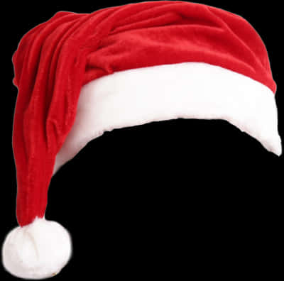 Kofia Nyekundu ya Santa Imetengwa kwenye Mandharinyuma Nyeusi Picha ya Ukuta