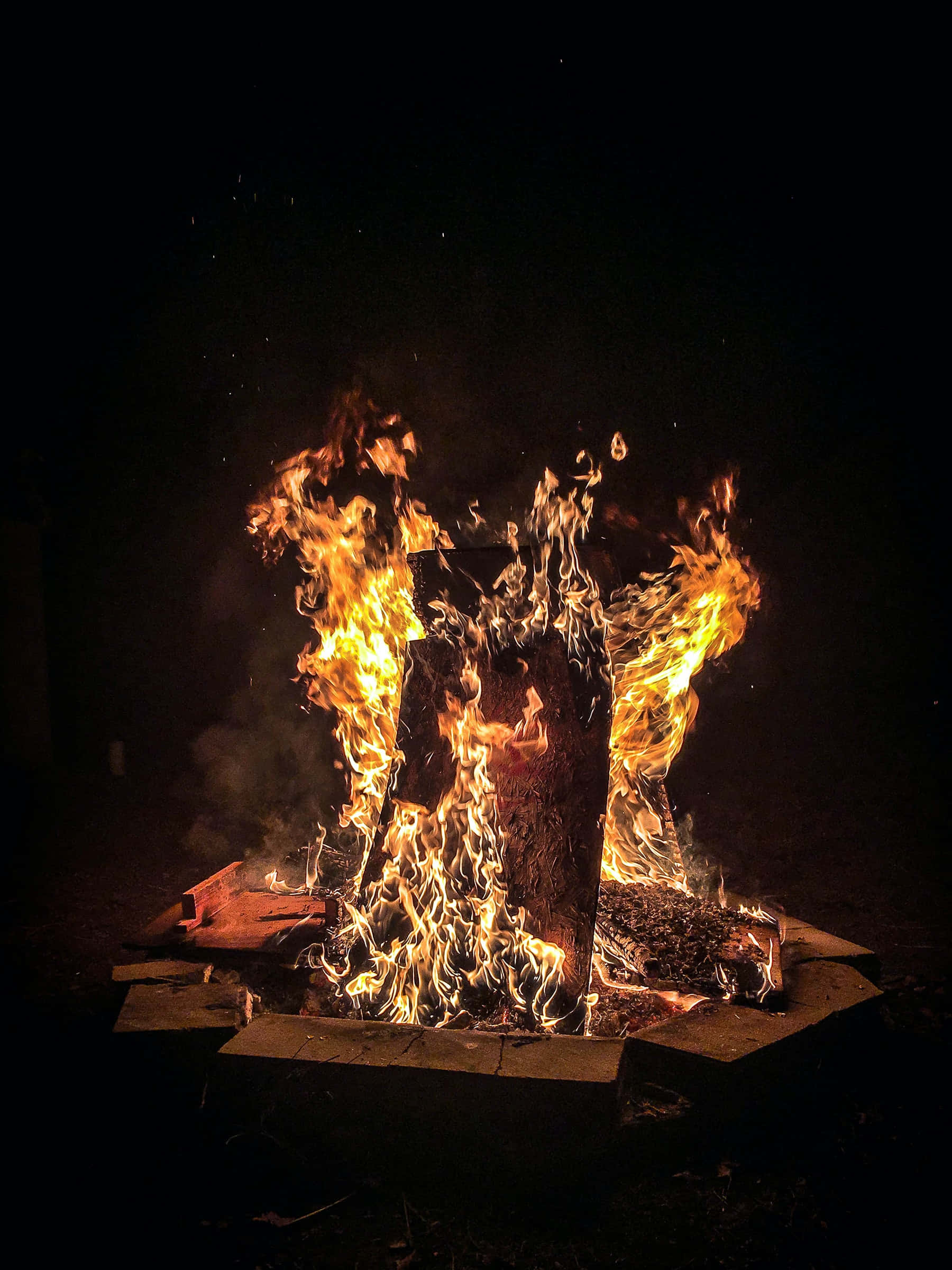 Kukusanyika Karibu na Moto wa Bonfire katika Usiku wa Mwanga Picha ya Ukuta