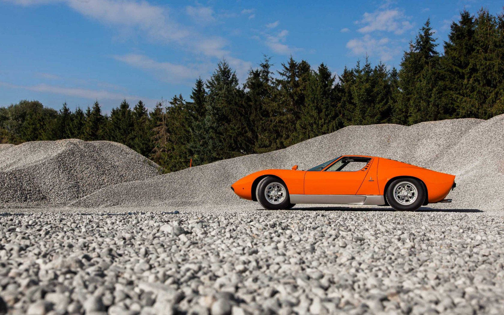Lamborghini Miura ya Kifahari ya Rangi ya Machungwa kwenye Barabara ya Changarawe Picha ya Ukuta