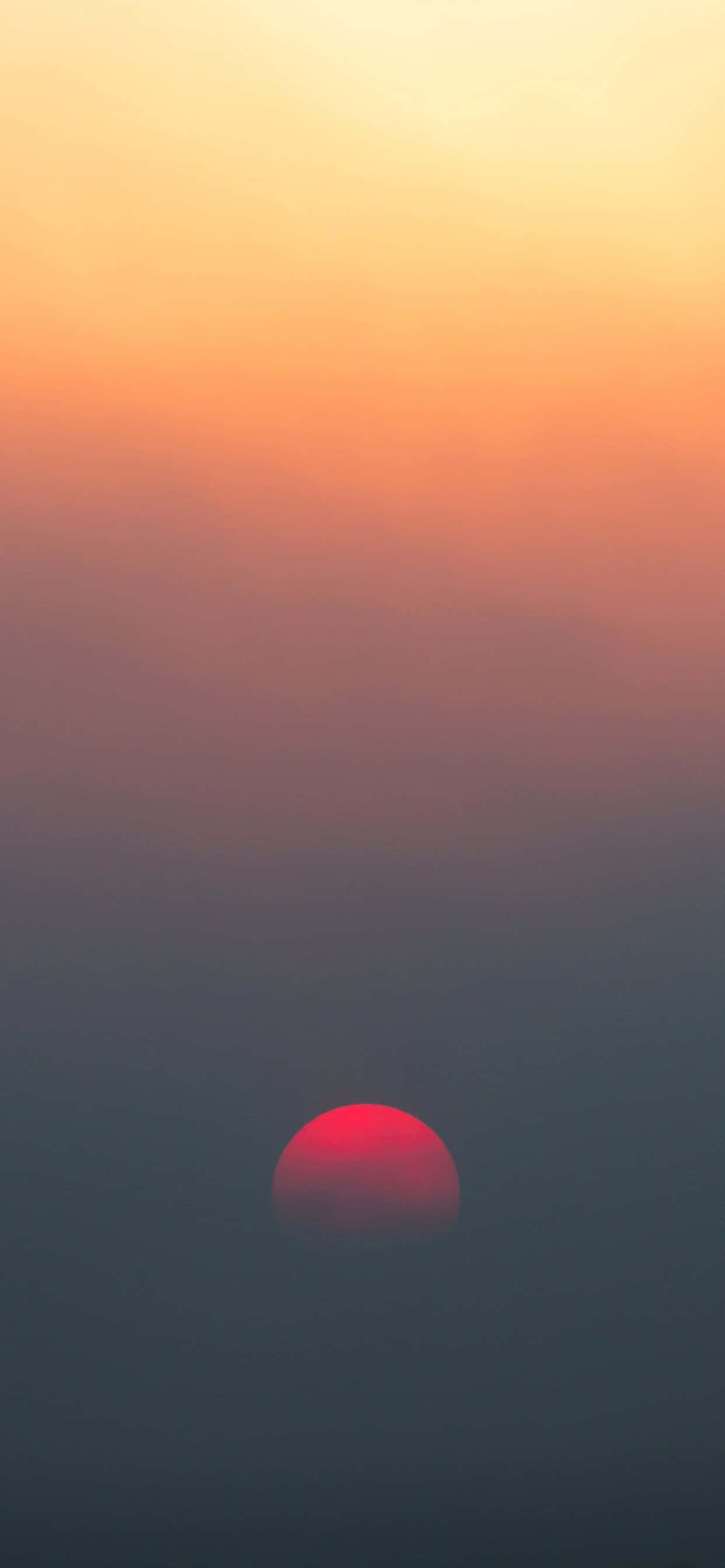a red sun rising over a fog filled sky Picha ya Ukuta