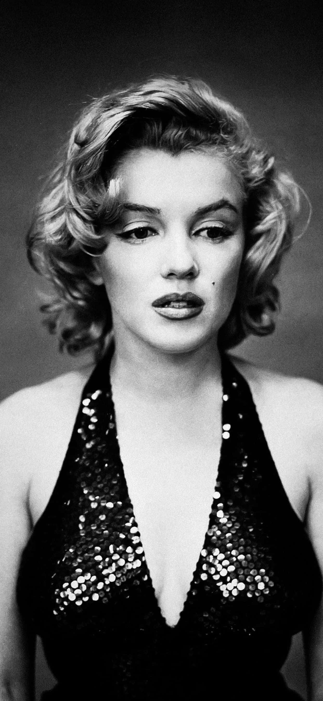 Marilyn Monroe Anapiga Picha kwa Mwoneko Wake wa Kipekee kwenye iPhone Picha ya Ukuta