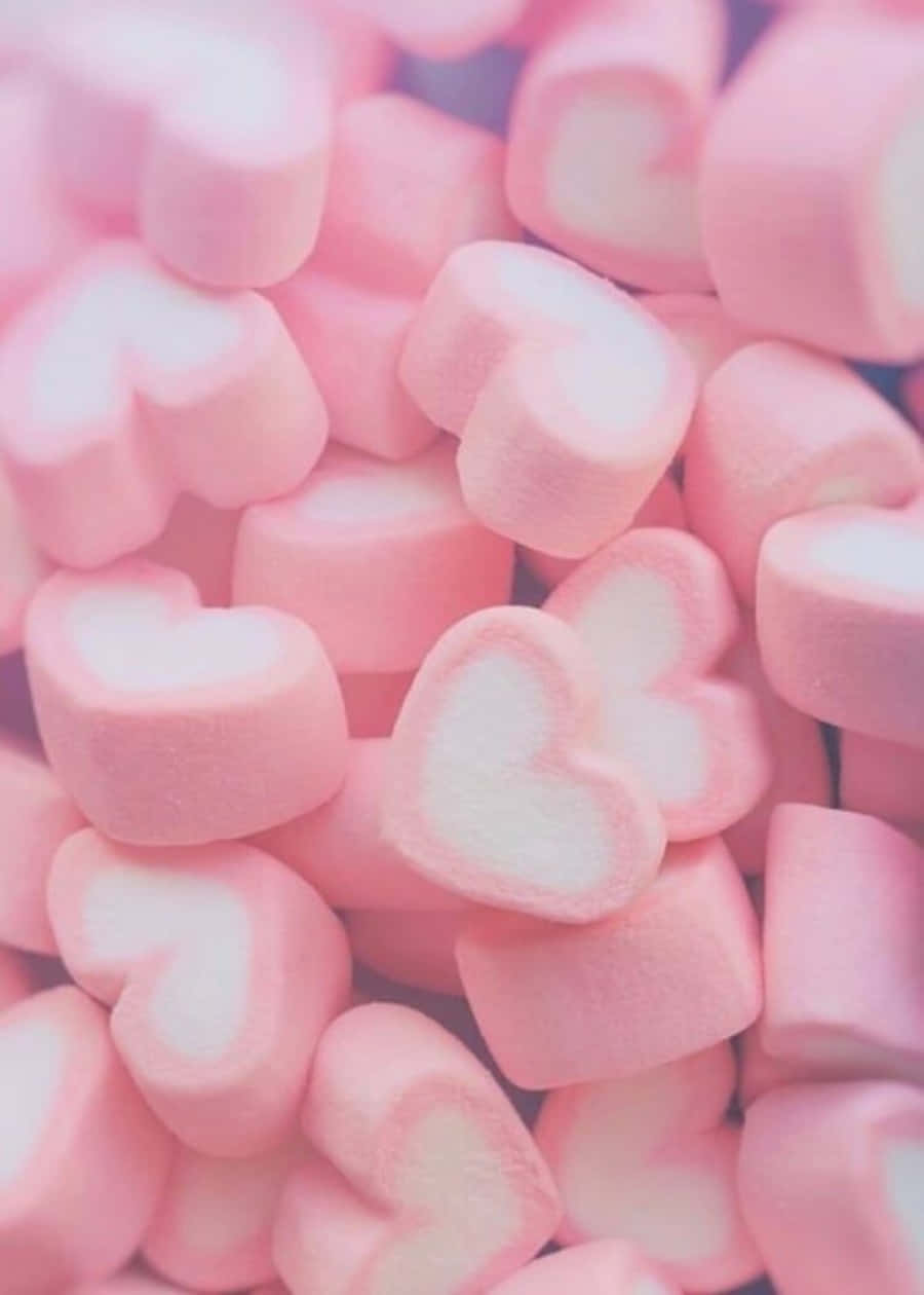marshmallows za pinki zilizorundikwa kwenye mandharinyuma nyeupe Picha ya Ukuta