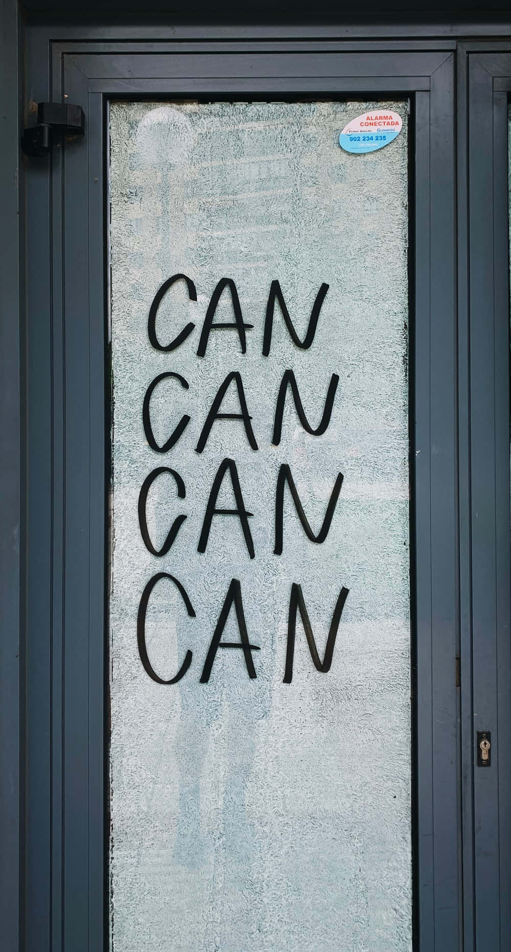 mlango wa glasi wenye maneno 'can can' juu yake Picha ya Ukuta