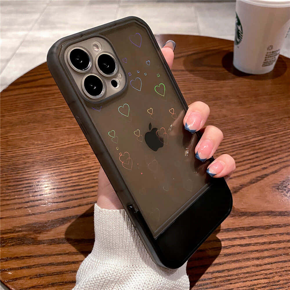 mwanamke anayeshikilia kipochi cha iPhone 11 chenye mioyo juu yake Picha ya Ukuta