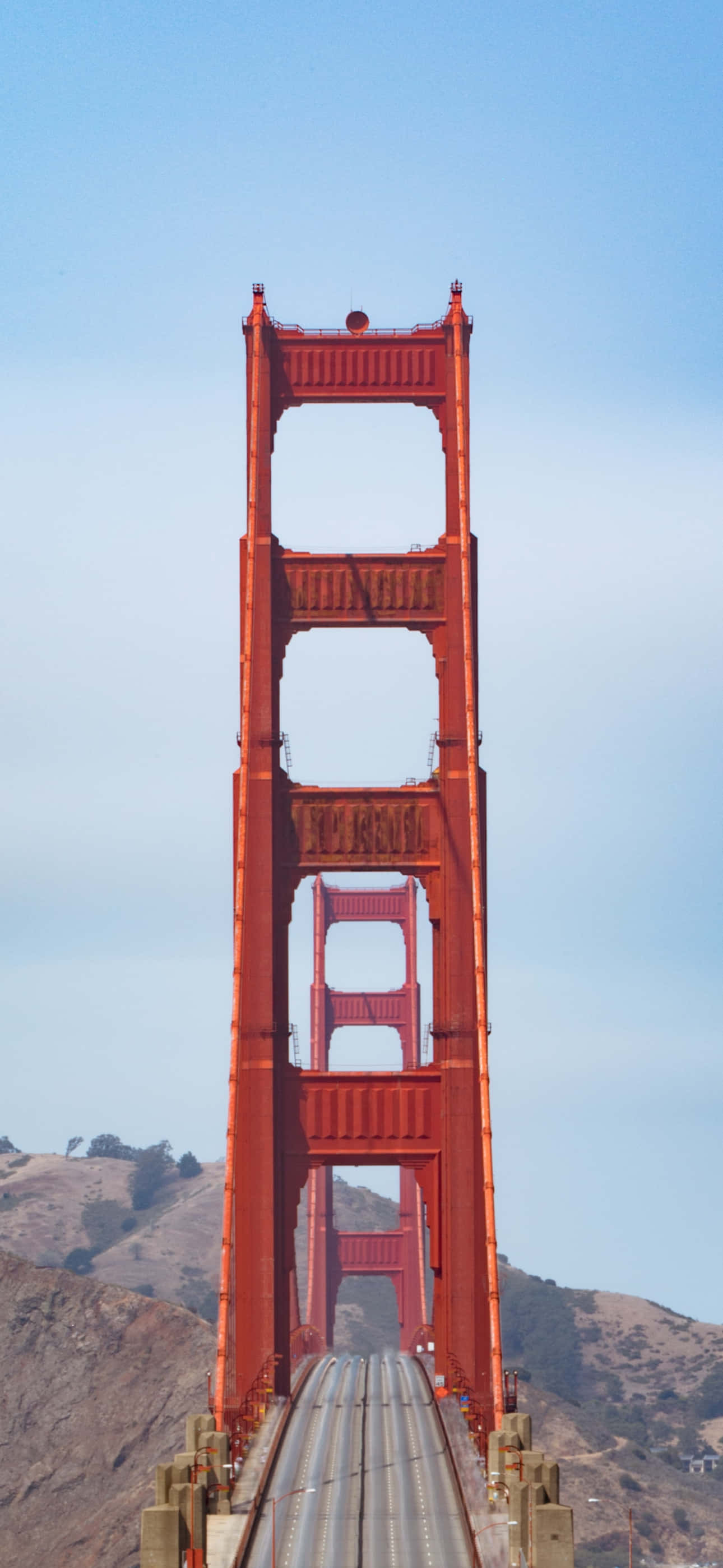 mwanaume anayewasha gari kuvuka Golden Gate Bridge Picha ya Ukuta