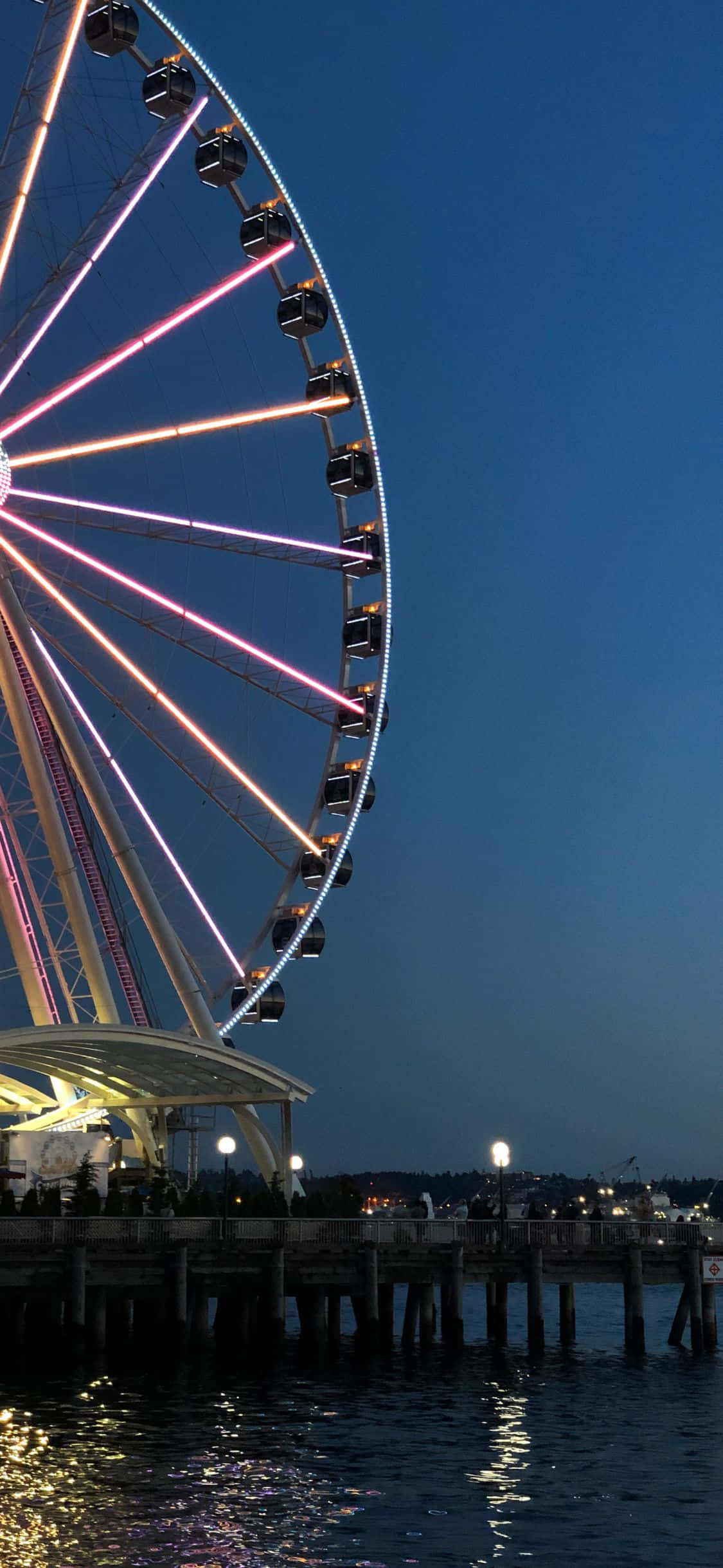 Nadhari ya aerial ya Seattle skyline, USA, wakati wa magharibi na mwangaza juu ya maji - iPhone X wallpaper Picha ya Ukuta