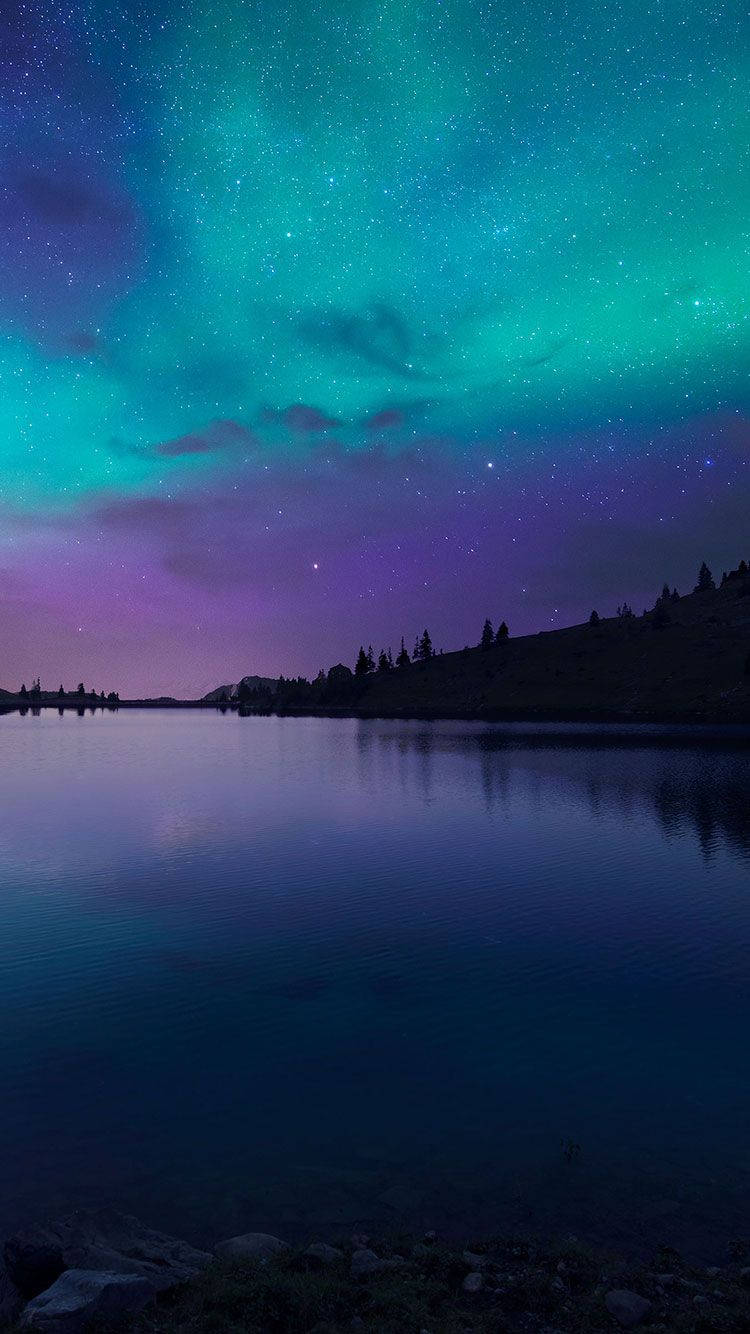 Nuru za anga: Anga la usiku linalong'aa na aurora borealis ya ajabu. Picha ya Ukuta