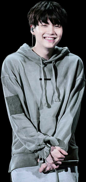 Nyota wa K-Pop Akitabasamu Amevaa Hoodie ya Kijivu Picha ya Ukuta