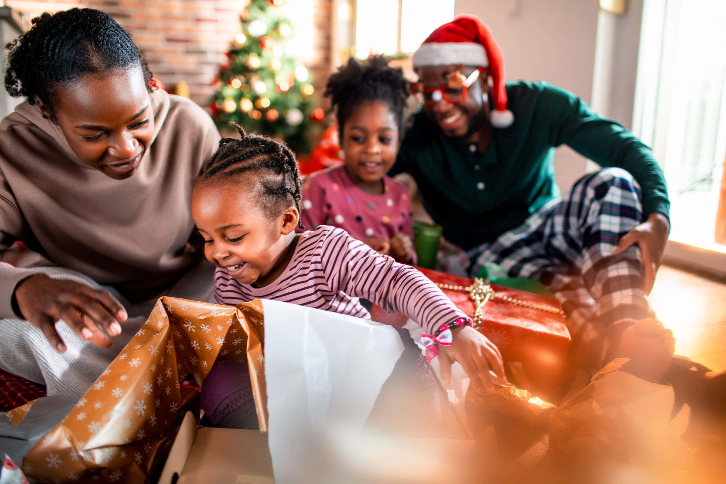 Picha ya Familia ya Kiafrika Ikifungua Zawadi za Krismasi Picha ya Ukuta