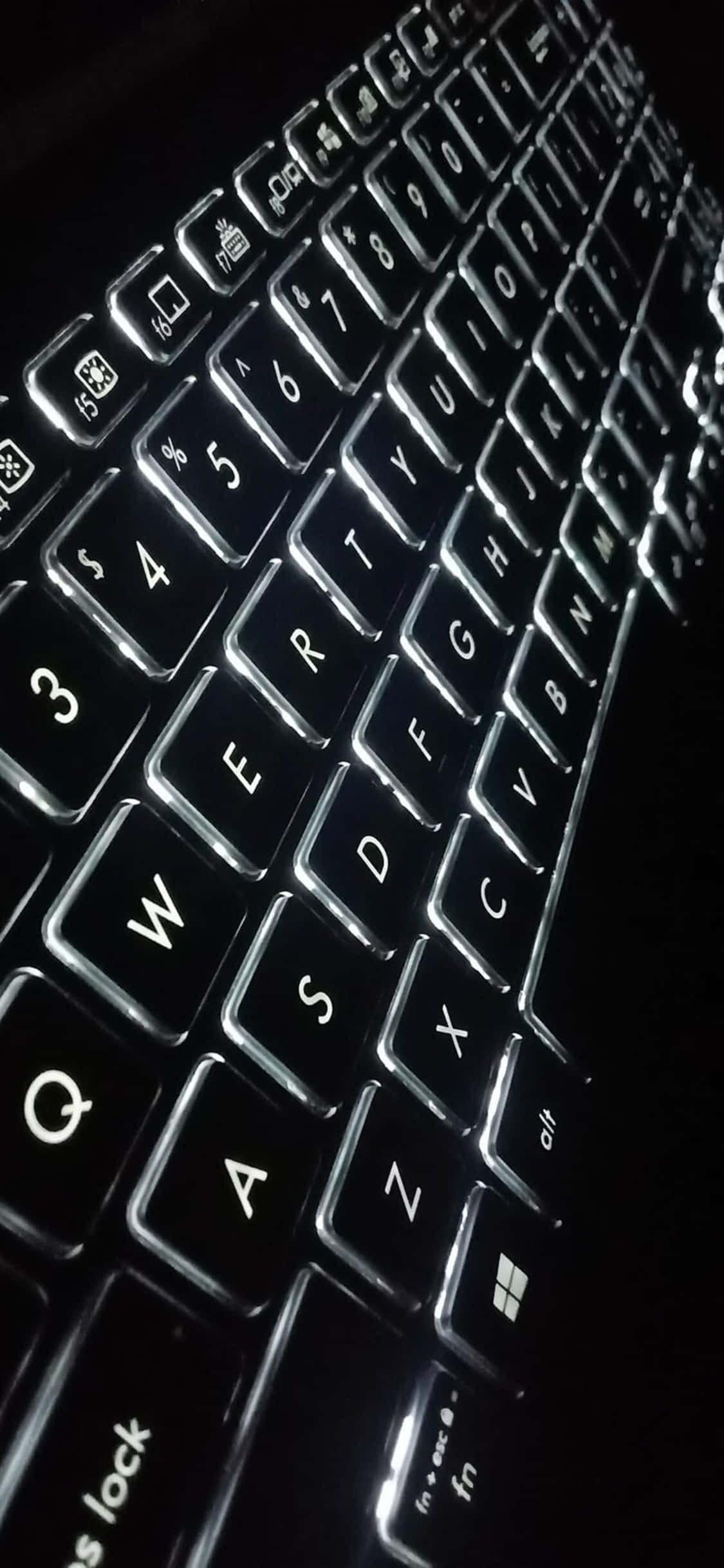 a close up of a keyboard in the dark Picha ya Ukuta
