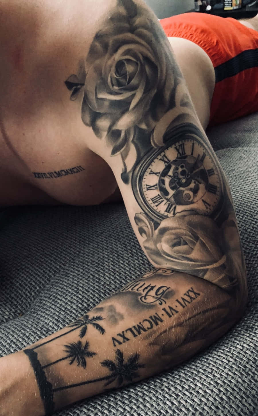 Picha ya Tatoo la Mwanamume na Waridi na Saa mkononi Picha ya Ukuta