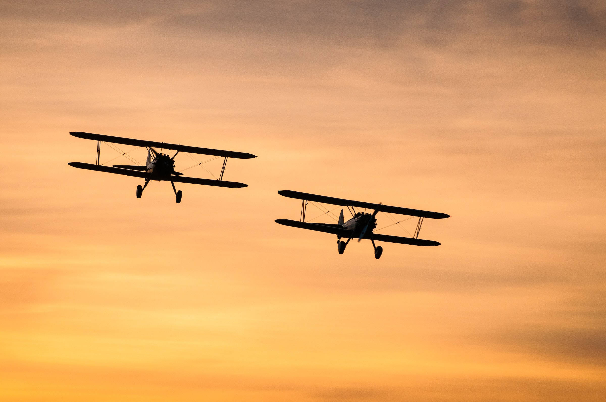 Silhouettes Nyeusi za Ndege Mbili za Biplane Angani Picha ya Ukuta