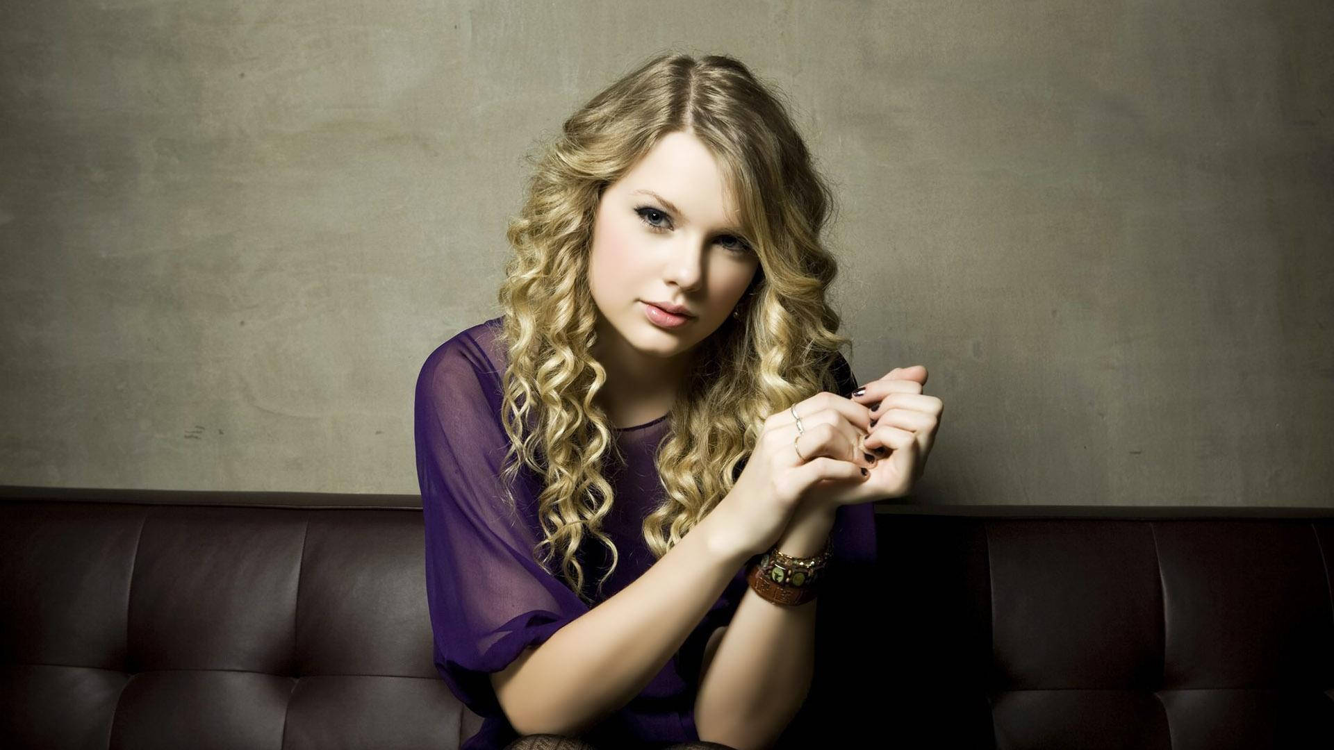 Taylor Swift akitoa nishati chanya kwa nywele zake za kipekee zilizojikunja. Picha ya Ukuta