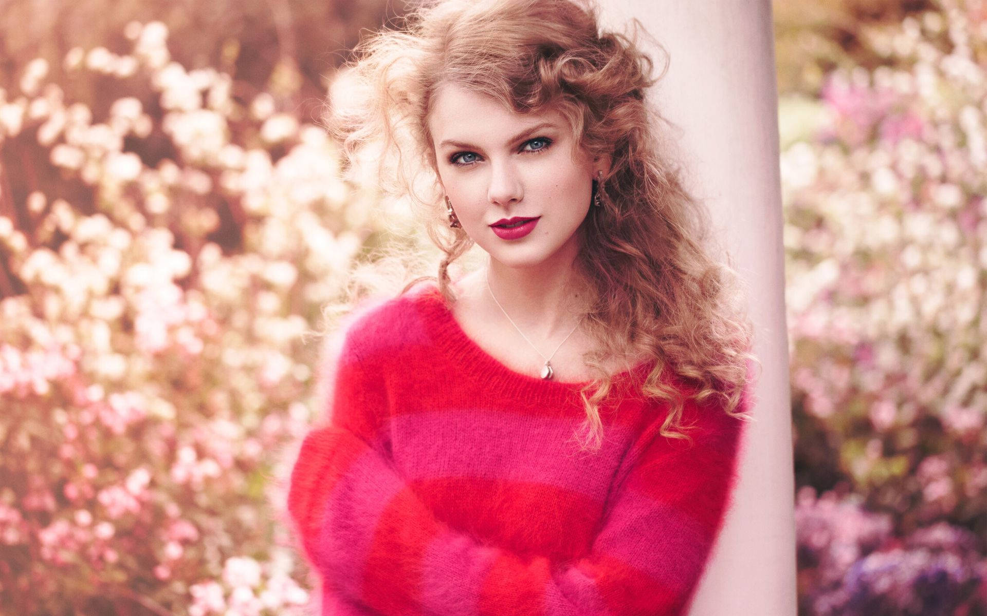 Taylor Swift akitumbuiza kwa mavazi ya waridi-nyekundu Picha ya Ukuta
