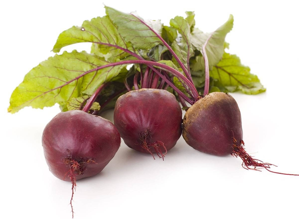 Viazi vitamu vyekundu mabichi na majani ya kijani Picha ya Ukuta