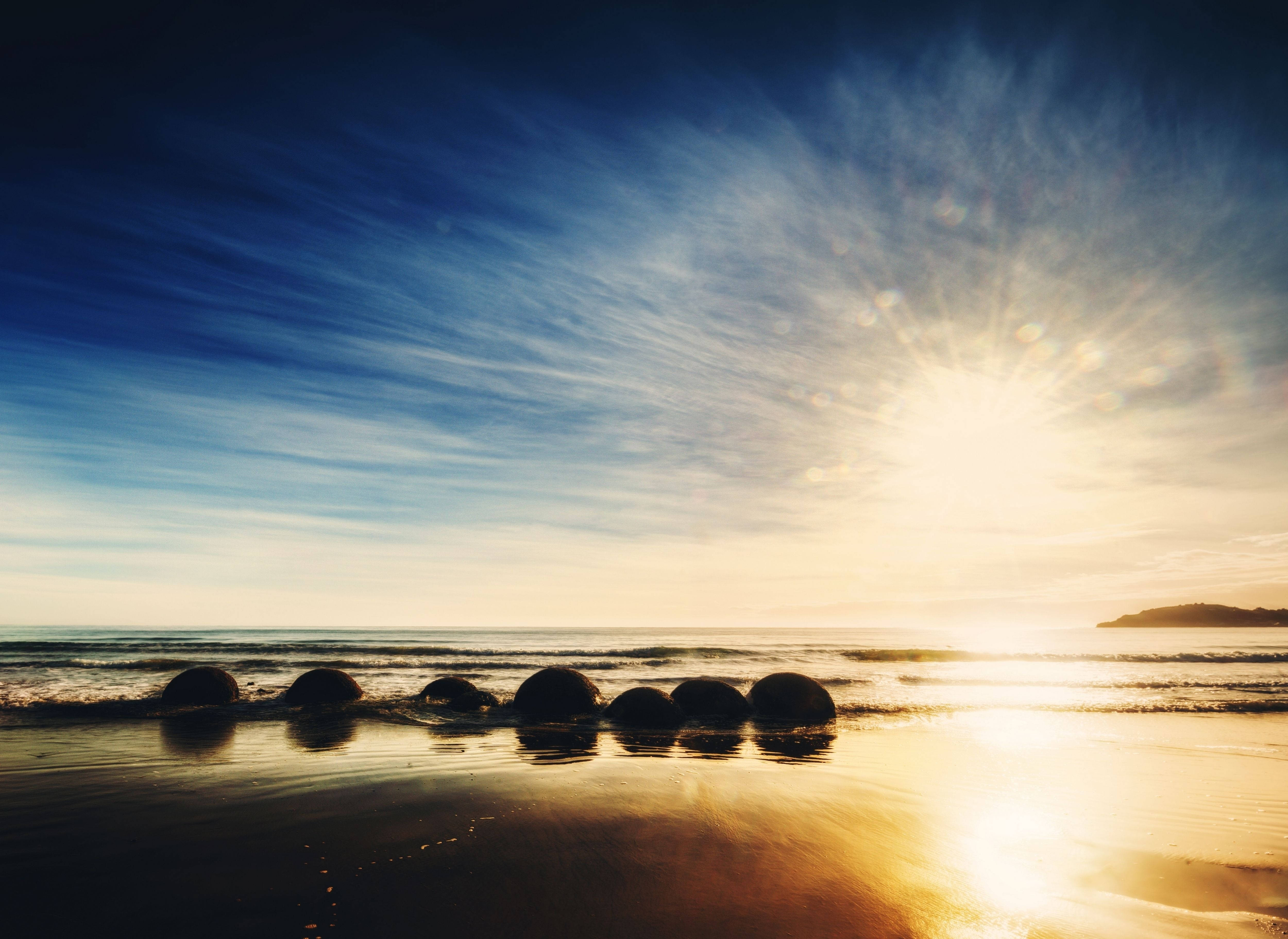 Washa na jua juu ya Moeraki Boulders Beach Picha ya Ukuta