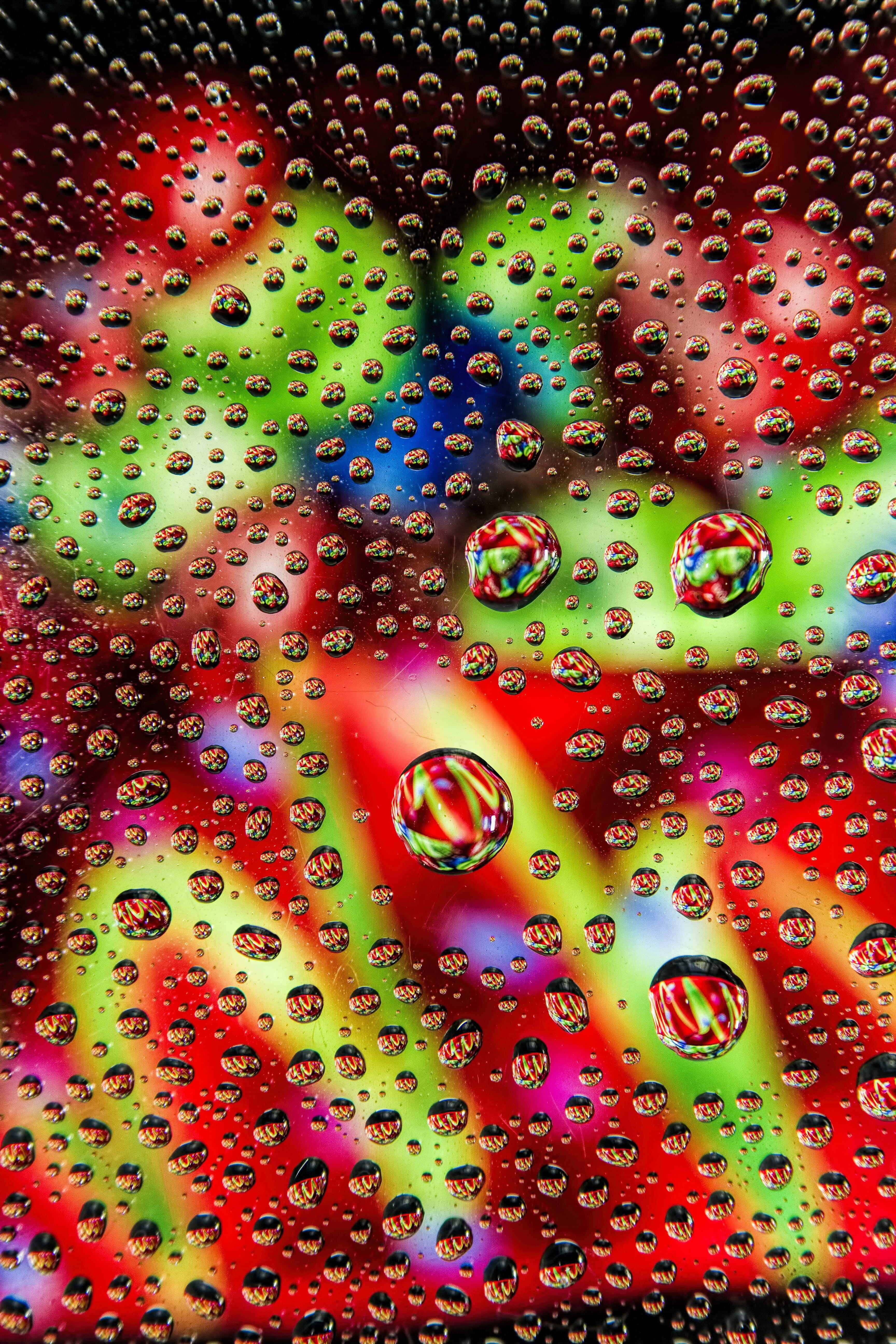 water droplets on a glass with colorful lights Picha ya Ukuta