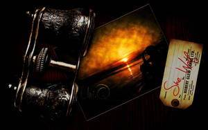 Classic binoculars beside a card and a vintage sunset photo wallpaper. — Mustawi Halisi Picha ya Ukuta