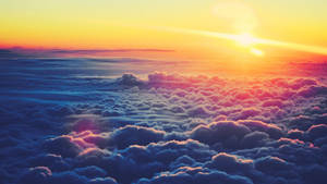 Yellow orange sunrise above sea of clouds wallpaper