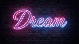 Alama ya neon 'Ndoto' yenye pink na bluu kwenye brick ya giza kwa amoled