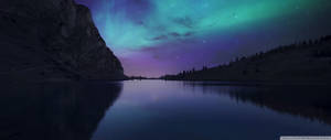 Ultrawide Aurora Borealis rangi ya pastel bluu na purpuri anga na mwanga kutoka milima