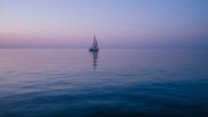 Boti moja ya sails juu ya maji ya bahari yenye nyendo katika magharibi. — Bahari Picha ya Ukuta