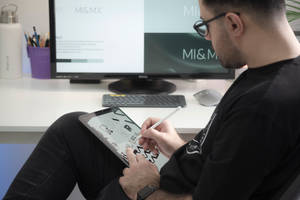 man in black long sleeve shirt sitting beside black flat screen computer monitor — iPad Mini Picha ya Ukuta