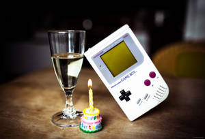 Nakala ya Game Boy na meza ya kioo na keki wallpaper