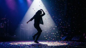 Silhouette ya mchezaji jukwaani na makaratasi ya rangi. — Muziki lenzi Picha ya Ukuta