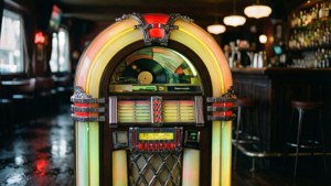 Jukebox yenye mwanga wa neon katika baa ya zamani yenye mazingira ya giza.